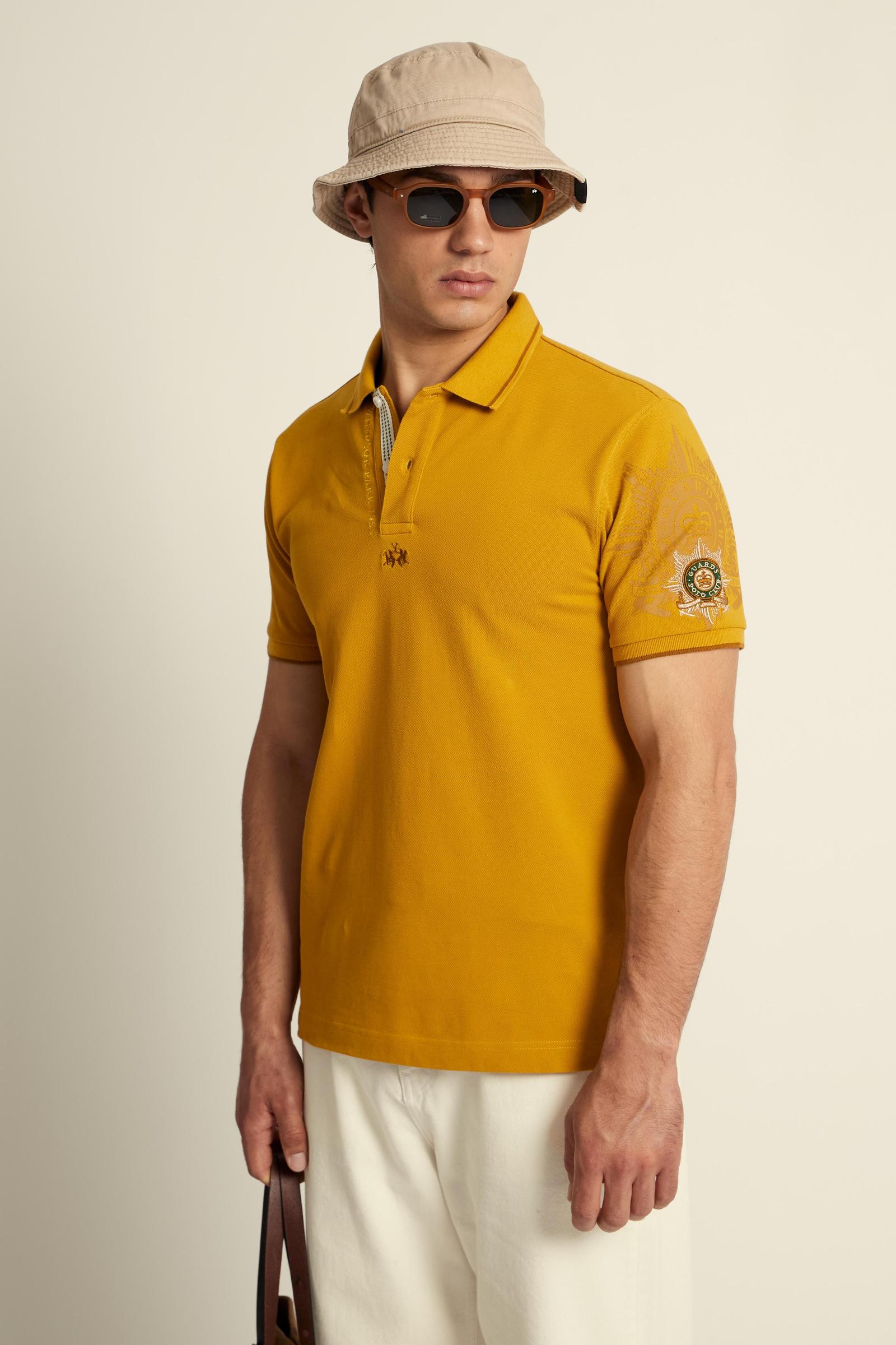 Men’s short-sleeve polo shirt in 100% cotton piqué with contrasting details, ribbed collar, and a unique graphic on the sleeve celebrating the Guards capsule - Tawny Olive