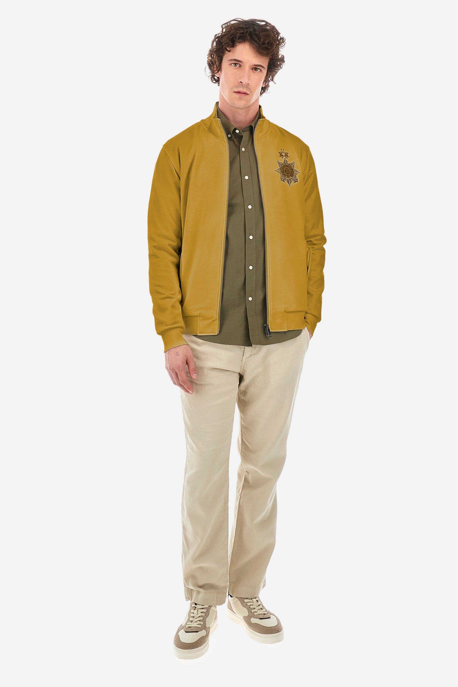 Men’s solid color long sleeve sweatshirt with full zip closure. Made of 100% cotton. High neck with drawstring, ribbed hem and cuffs. Double front pocket with button closure. Writing and large symbol on the chest identify the capsule collection. The fit is regular. The model wears a size L. - Arrowwood