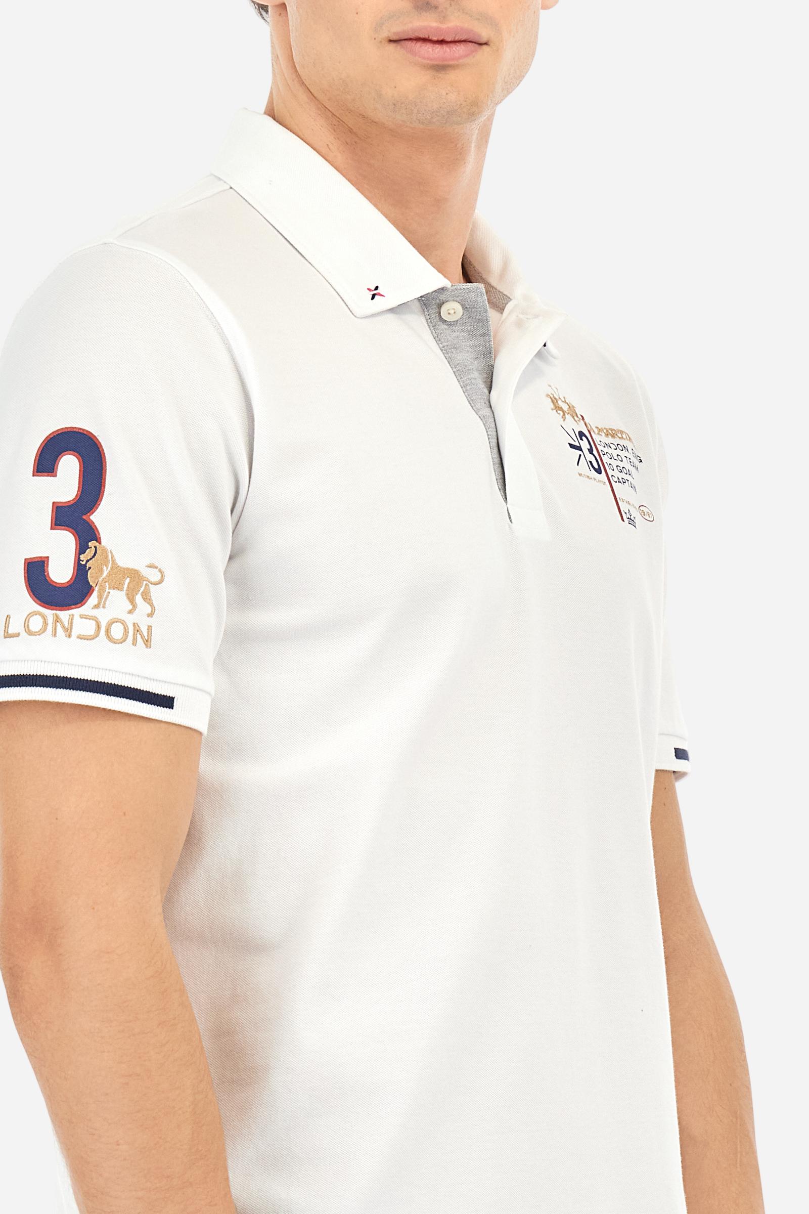 Short-sleeved, single-colour men's polo shirt made of stretch cotton piqué. Fastens with two buttons and internal opening, button side, in contrasting fabric. Ribbed collar and cuffs. The cuffs feature an inlaid detail in a contrasting colour. The graphics on the chest and back are made with mixed techniques: printing and embroidery. The logo is embroidered on the chest, left side. The fit is regular. The model is wearing a size L. - Optic White