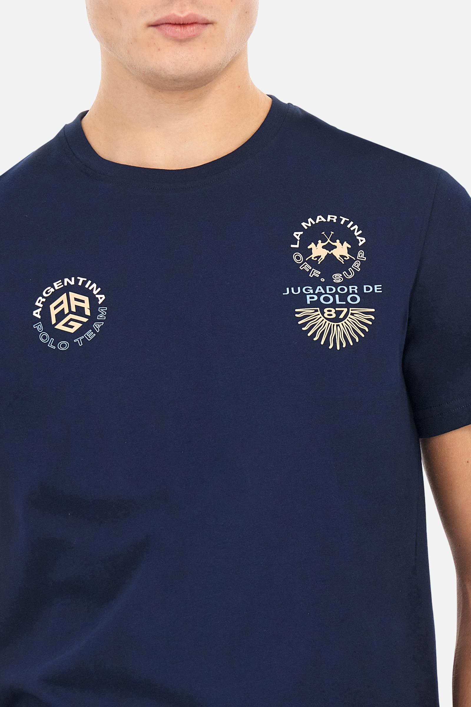 Men's plain cotton jersey T-shirt. Crew-neck model with matching ribbed collar. A contrasting jersey ribbon is applied on the inside of the collar. On the chest we find two graphics, both printed with contrasting colours and gold, that make references to Argentina. On the right sleeve the number 3 is present as a two-tone print with a slightly rubberised appearance. The logo and the La Martina lettering are printed on the chest, left side. Regular fit. The model is wearing a size L. - Navy