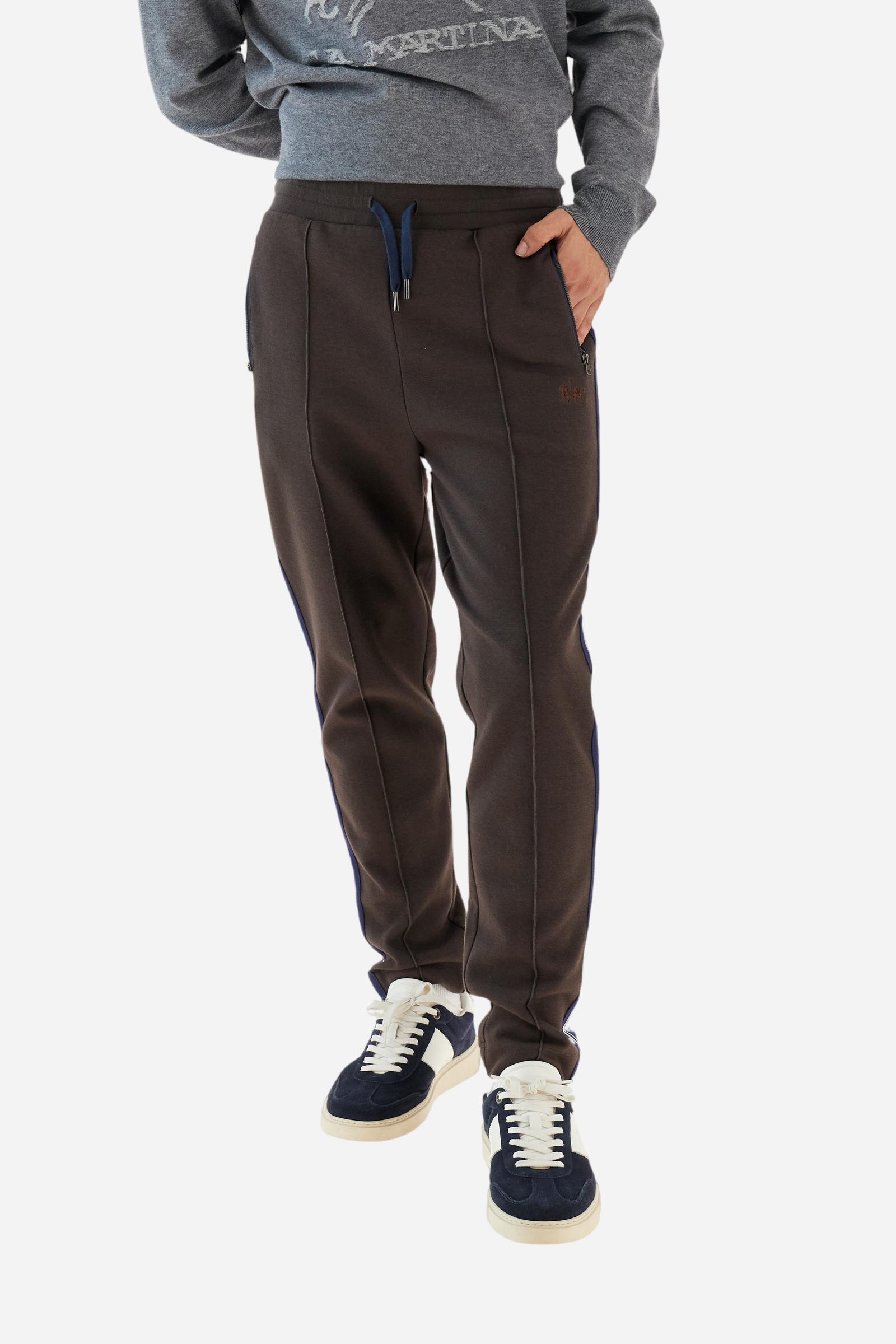 Men’s joggers made of 100% cotton interlock fleece with a bicolor design. Elastic waistband with drawstring for a customizable fit. Two zipped side pockets add practicality, while multicolor striped tape decorates both sides. A vertical crease on the front leg adds refinement to this sporty style. Small embroidered logo in contrast under the left pocket. Regular straight-leg fit for a classic, comfortable silhouette. Model wears size L. - Java