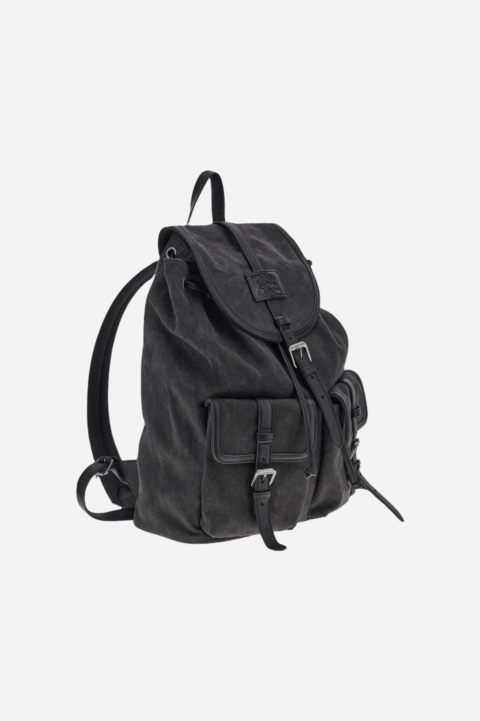 Backpack in washed canvas with leather details, resistant and practical, designed for travel lovers. Featuring a double closure with drawstring and flap with magnetic button, large front pockets for extra space, and a hot-stamped logo on the leather tag of the flap. Dimensions:31 x 40 x 14 - Black