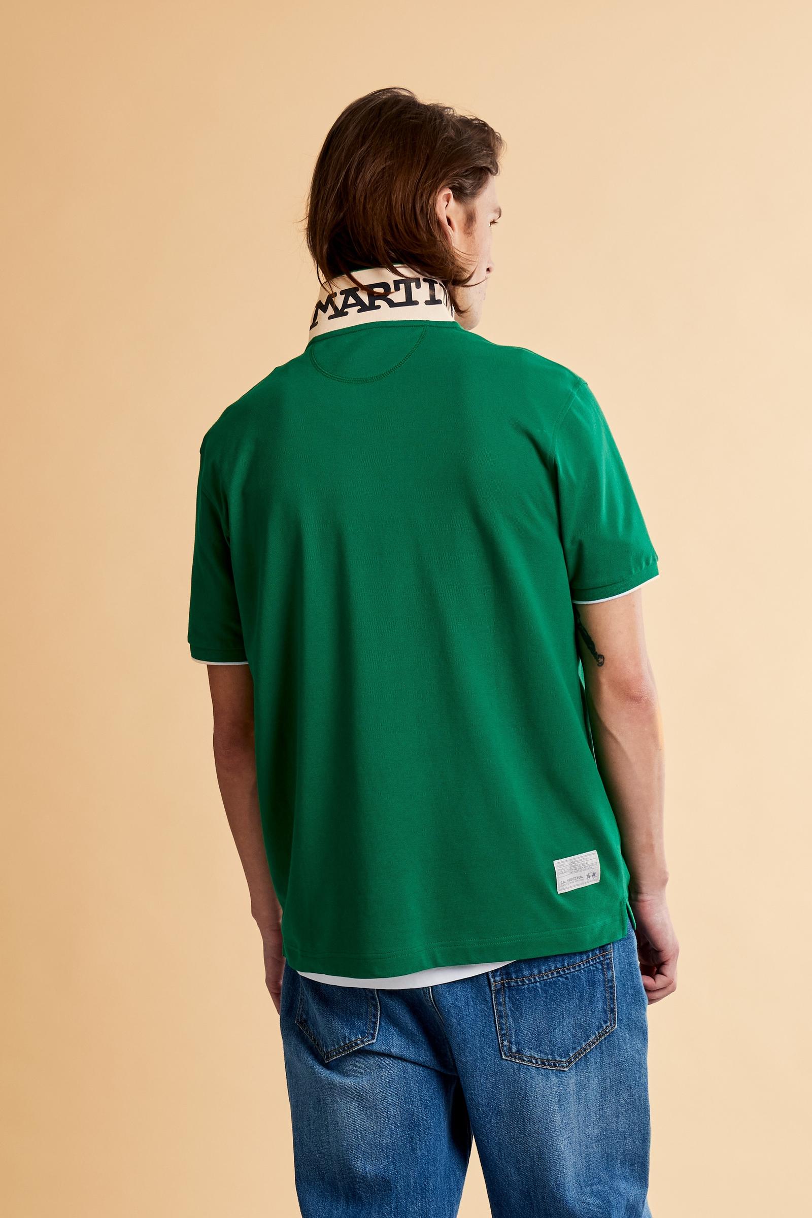 Men's short-sleeve polo shirt made from solid-color stretch piqué fabric. The model features a two-button front placket with ribbed collar and cuffs in matching tone. An iconic design of the brand, it stands out for the large embroidered team logo in contrasting color on the chest and the bold brand print under the collar in contrasting color. The regular fit ensures comfort and versatility for everyday wear. The model is wearing size L. - Amazon