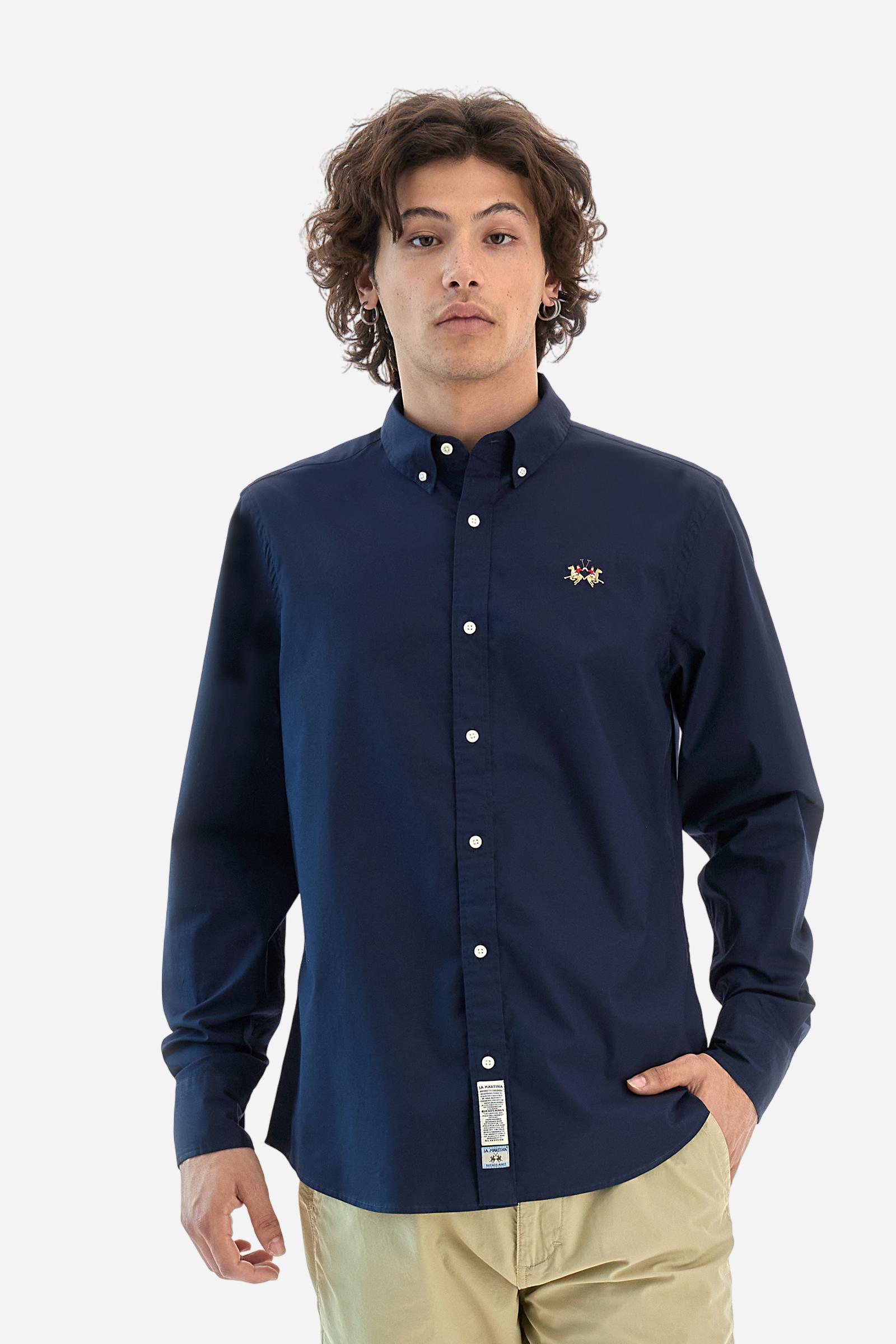 Men's plain long-sleeved shirt made from stretch cotton poplin for a comfortable fit. Featuring a button-down collar and woven labels at the bottom of the opening. A multicoloured logo is embroidered on the chest, over the heart, in contrasting thread. The slim fit ensures a sleek and modern look. The model is wearing a size L. - Navy