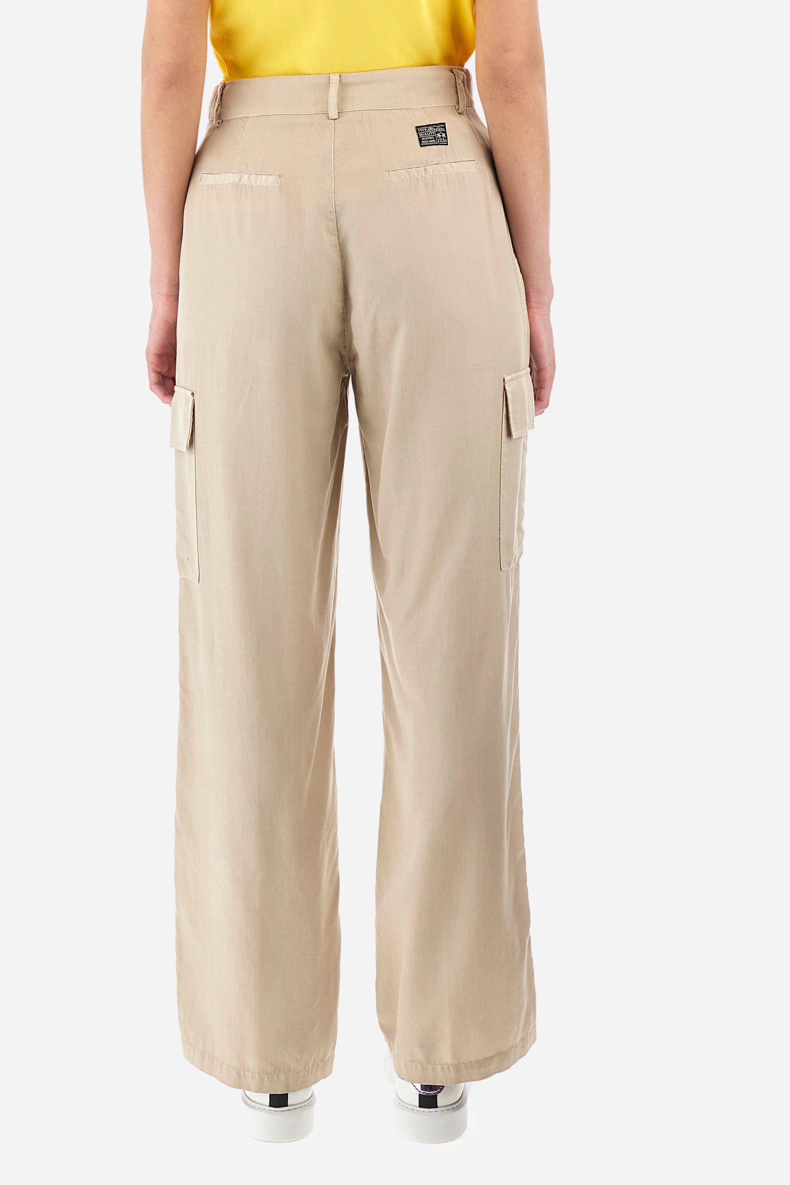 Single-colour women's cargo trousers, in an ecological fabric. With belt loops, zip and button fastening. There are two open front pockets, two cargo pockets and two further open pockets on the back. The logo is present on a patch sewn on the back and on a metal plate sewn on the front. The fit is regular. The model wears a size 40. - Tidal Foam