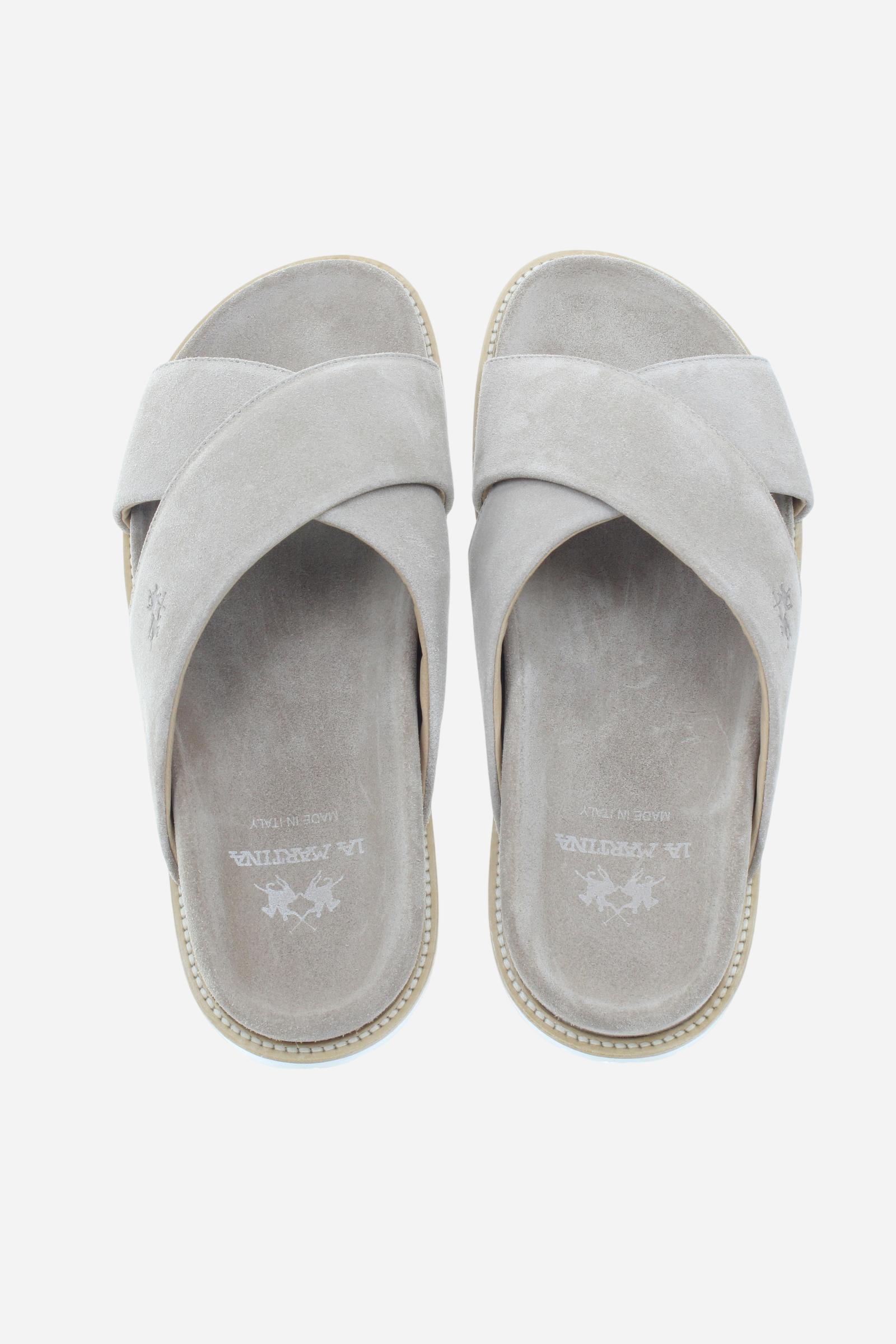 Men’s slides, lightweight and comfortable, featuring a suede upper that offers softness and refined aesthetics. The leather welt, stitched directly to the upper, highlights the craftsmanship and attention to detail. The model is enriched with a printed logo on the covered footbed and horse motif on the side strap. The ultra-light EVA sole ensures flexibility, cushioning, and freedom of movement, making these slides ideal for everyday comfort with a refined style. - Sand