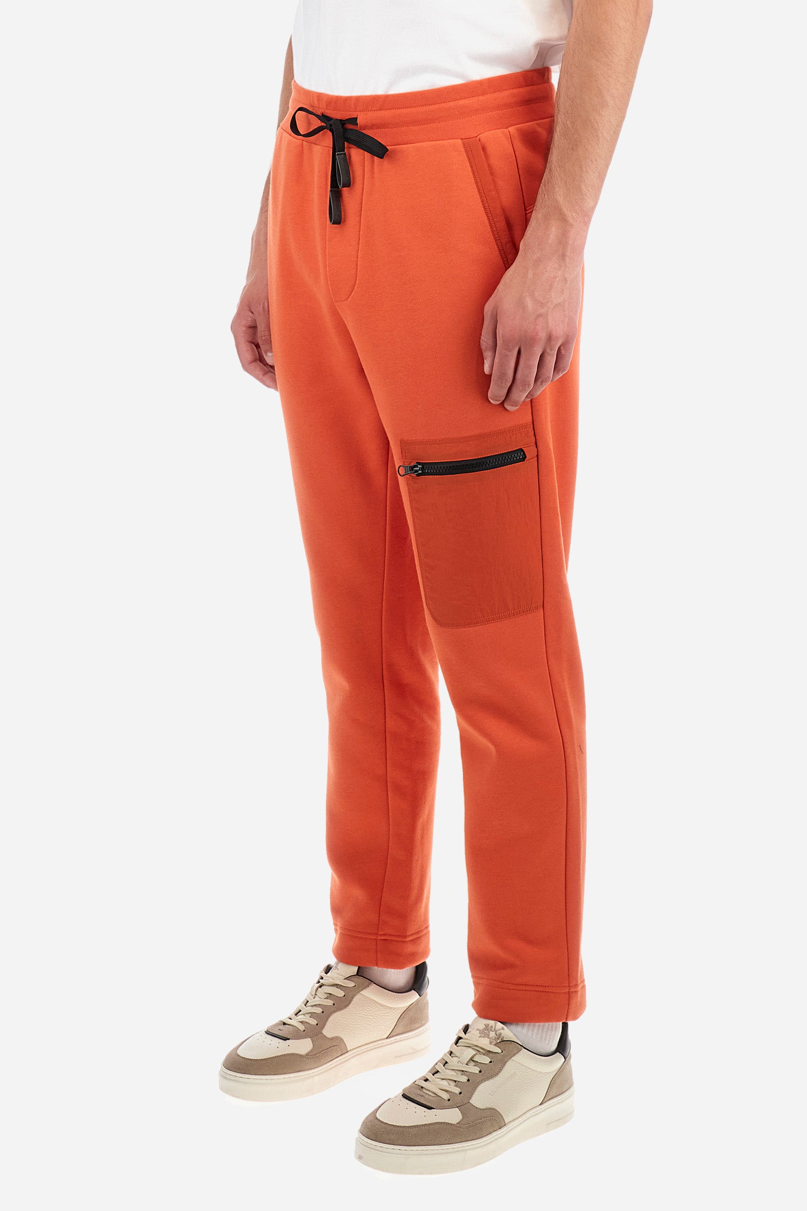 Men's plain jogging bottoms, made from a cotton blend. Drawstring waist and cuffs. Double front pocket. There is an additional zipped pocket on the front. The logo appears on an appliquéd plaque the back. Regular fit. The model is wearing a size L. - Pureed Pumpkin