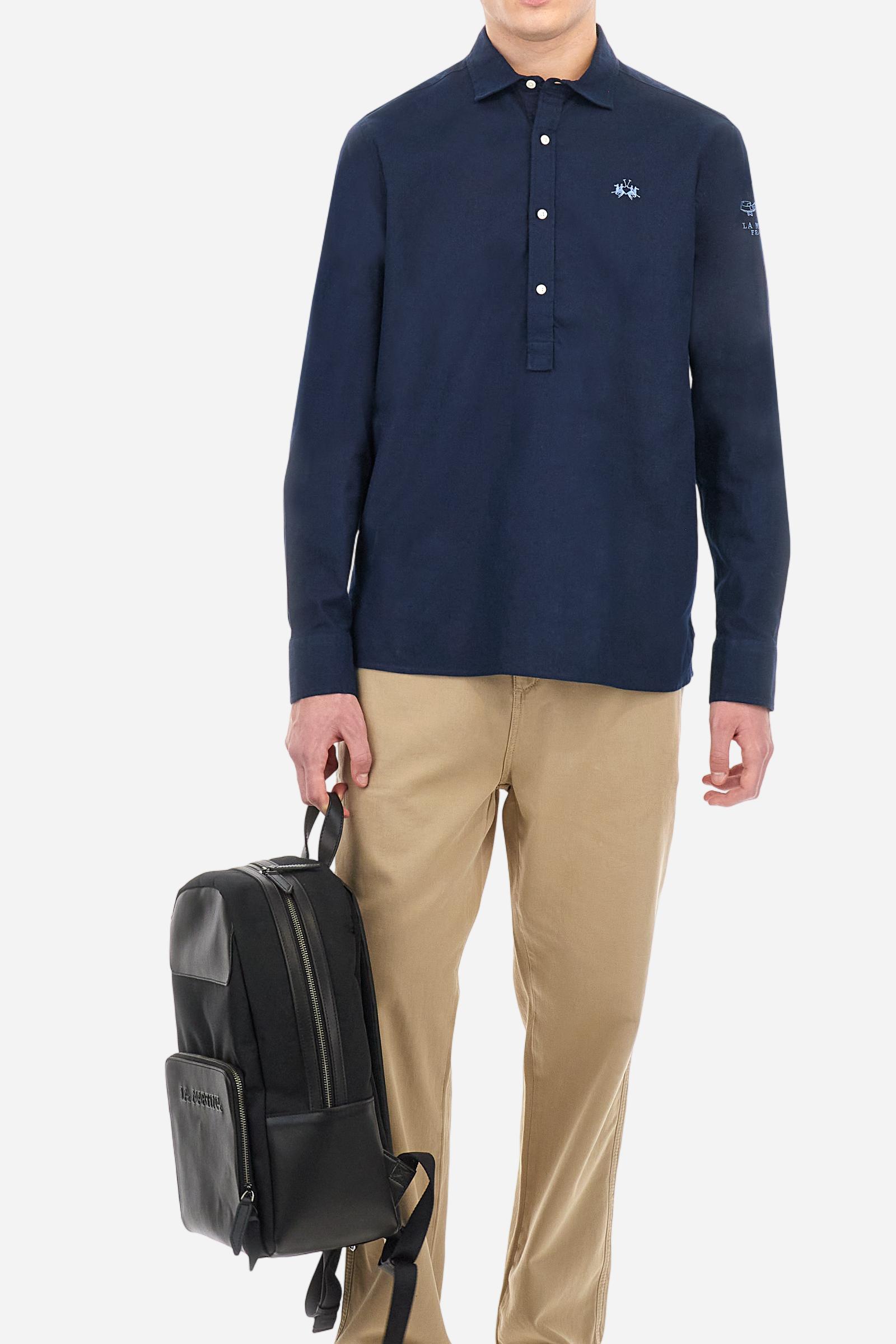 Men's plain long-sleeved shirt, made from luxurious cotton and linen canvas. The spread collar and the opening, which reaches the waist, are closed with 4 buttons. The left bicep is embellished with embroidered graphics depicting lettering, crests and numbers, created using contrasting thread. The logo is embroidered in contrasting thread on the left side of the chest. The regular fit offers a refined and comfortable look. The model is wearing a size L. - Navy