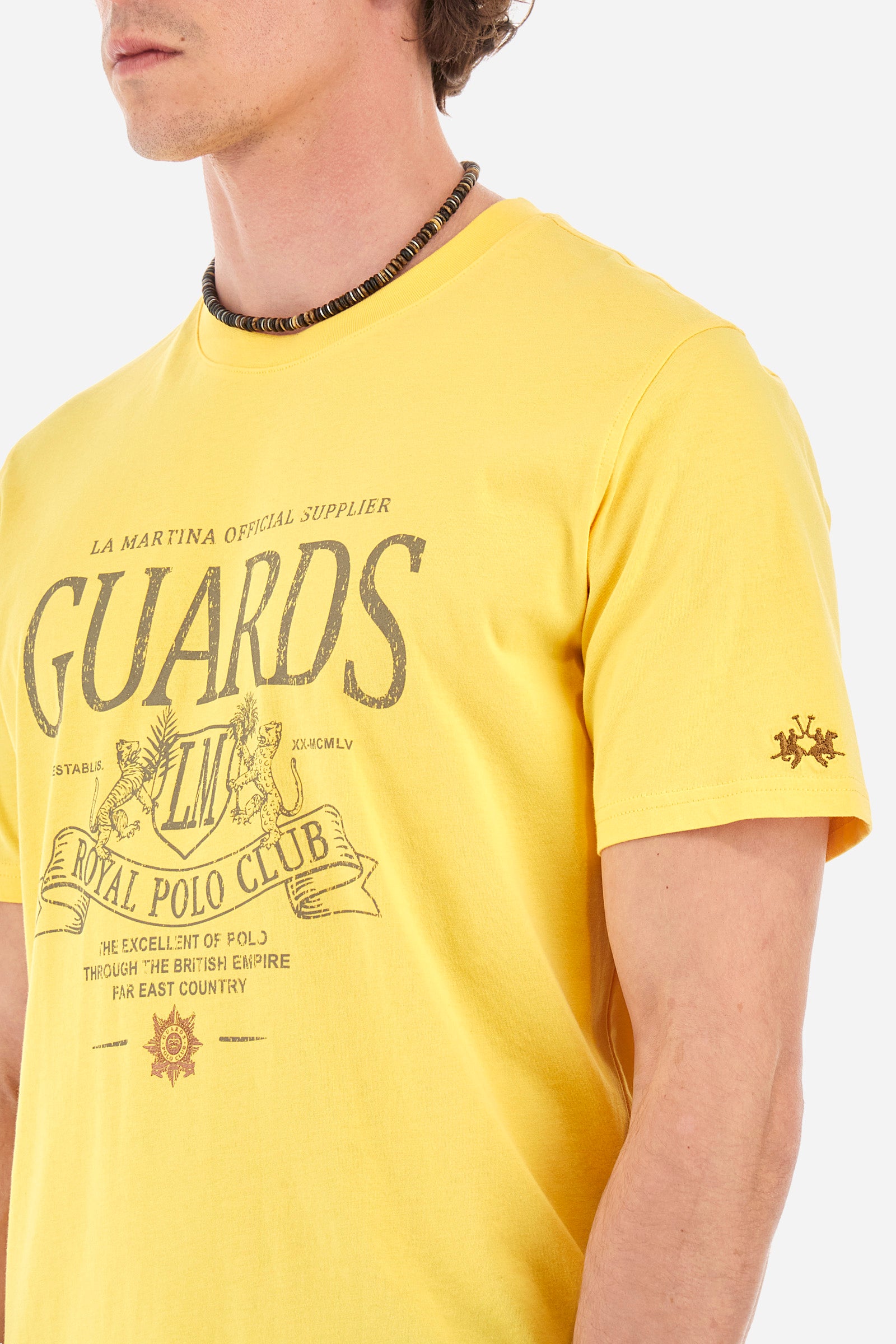 Men’s short-sleeved t-shirt, crew neck, solid color. Made of 100% cotton jersey. Small and large prints and symbols in contrasting tones identify the Guards capsule collection. Regular fit. The model wears a size L. - Aspen Gold