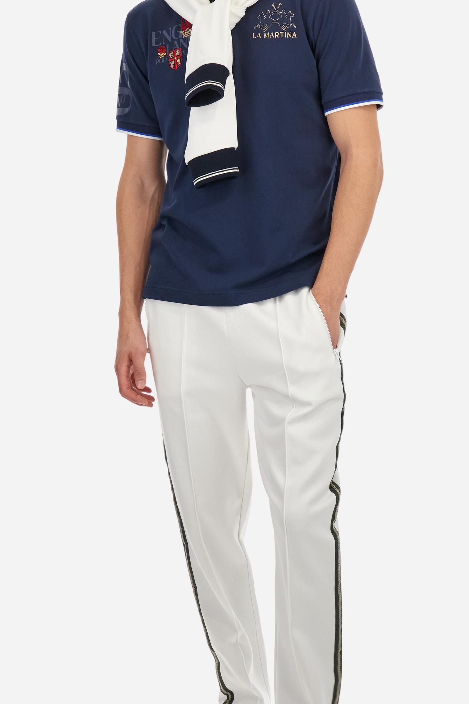 Men's solid color polo shirt, made of slightly elasticated cotton piqué. Two-button closure. Ribbed collar and sleeve hems, with a contrasting two-tone detail at the bottom of the sleeves. The entire garment features details crafted using mixed techniques. Both the front and back display embroidery and prints. The logo and the La Martina lettering are embroidered on the left chest. The fit is regular. The model is wearing size L. - Navy