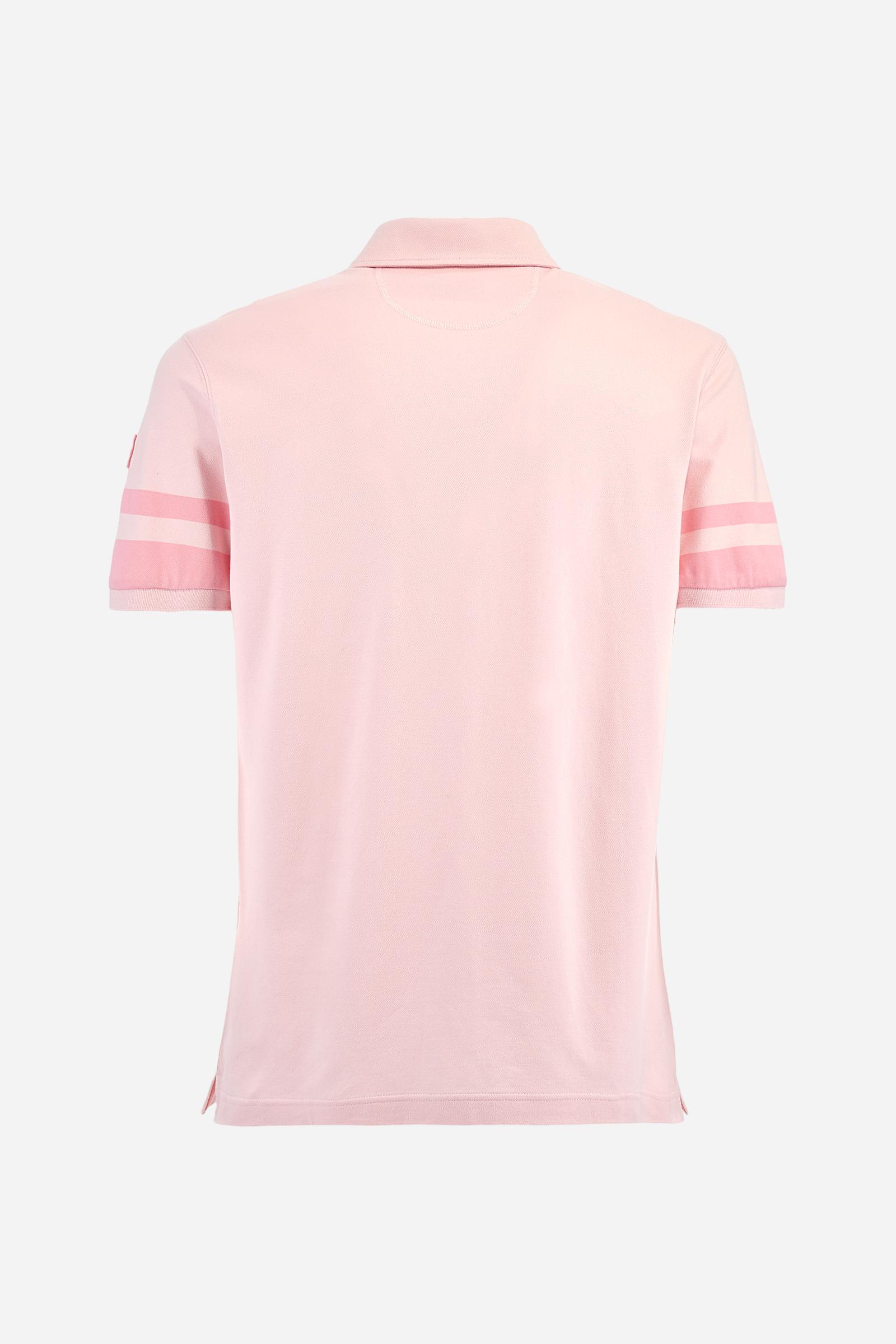 Short-sleeved, single-colour men's polo shirt made of stretch cotton piqué. Fastens with two buttons. Sleeve details in fabric with colour-contrasting irregular band pattern. Ribbed collar with brand name embroidery in contrasting colour. The front graphics are embroidered, the large central lettering is a flocked transfer, while the flag on the sleeve is an applied patch. The logo is embroidered on the chest, left side. The fit is regular. The model is wearing a size L. - Parfait Pink