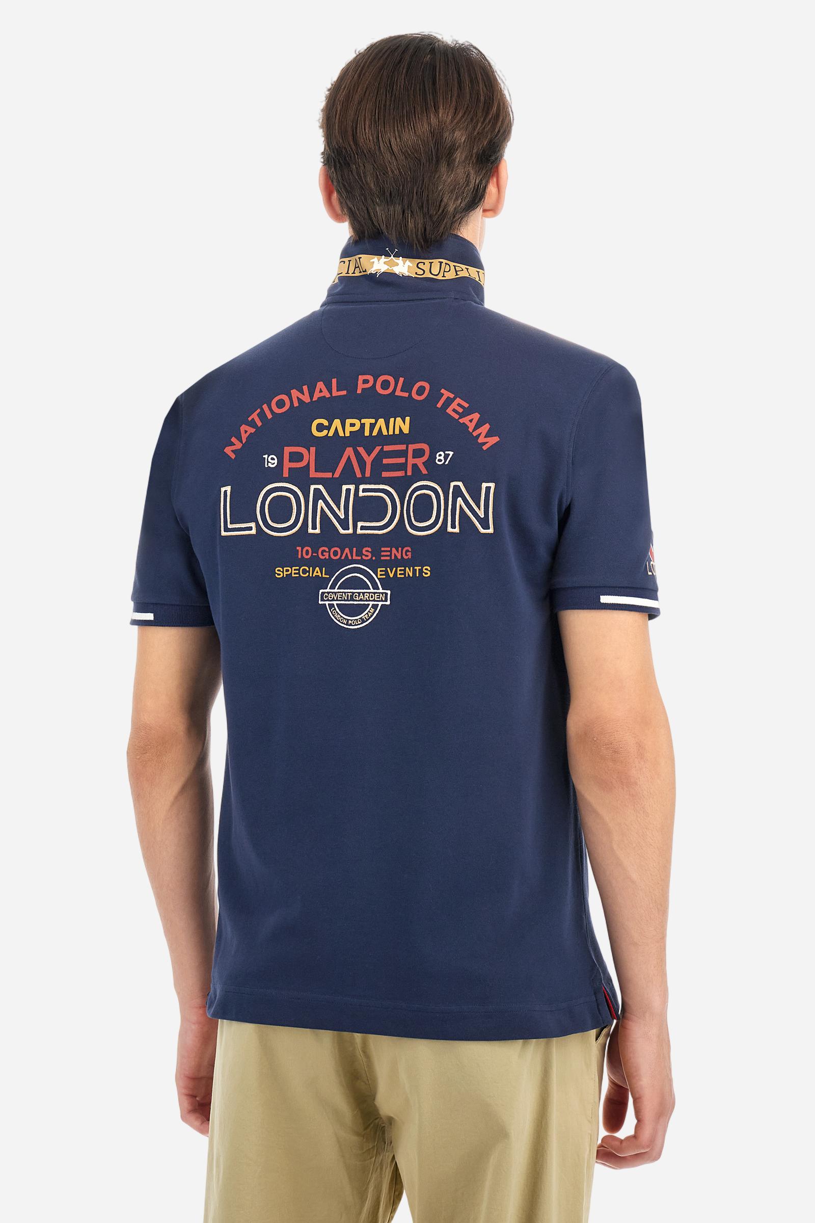 Short-sleeved, single-colour men's polo shirt made of stretch cotton piqué. Fastens with two buttons and internal opening, button side, in contrasting fabric. Ribbed collar and cuffs. The cuffs feature an inlaid detail in a contrasting colour. The graphics on the chest and back are made with mixed techniques: printing and embroidery. The logo is embroidered on the chest, left side. The fit is regular. The model is wearing a size L. - Navy