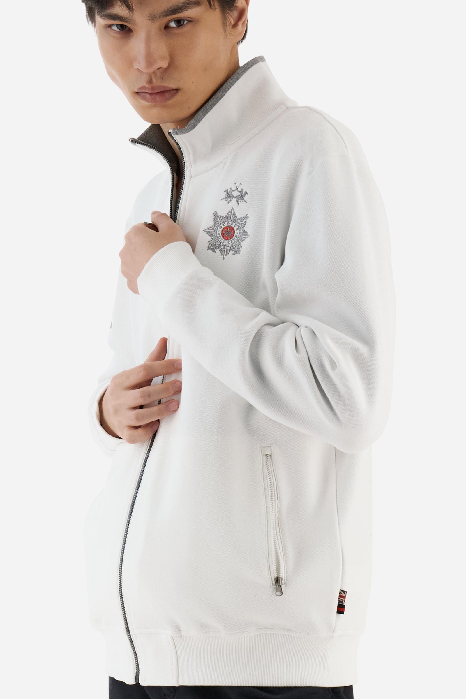 Men's long-sleeved, full-zip solid colour sweatshirt. Made of stretch cotton-blend piqué. Design with front opening fastened by a zip, high collar in two-tone ribbing. Solid colour ribbed cuffs and waistband. The small brand logo and Guards crest are embroidered in multi-coloured thread on the chest. On the right sleeve, there is another embroidery of a crest inspired by the British royal household. The regular fit silhouette is practical for everyday wear. The model is wearing a size L. - Off White