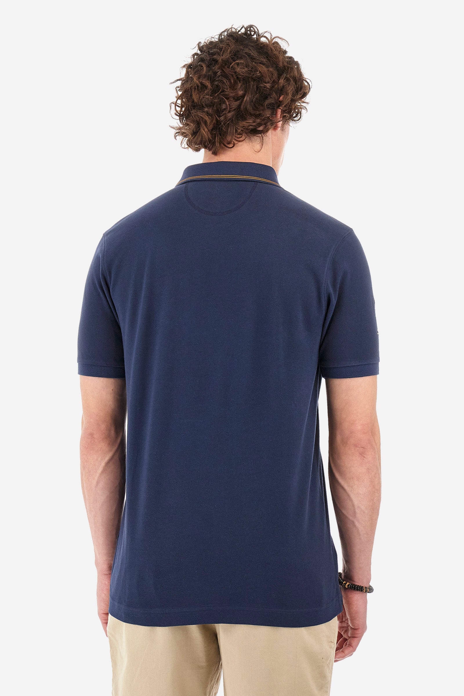 Men's single-colour short-sleeved polo shirt in 100% cotton. Two-button fastening. Collar with two contrasting stripes and ribbed armholes. On the front we find lettering and the symbol representing the Guards line. The brand's initials, the number 55 and the logo are embroidered on one of the sleeves. The fit is regular. The model wears a size L. - Navy