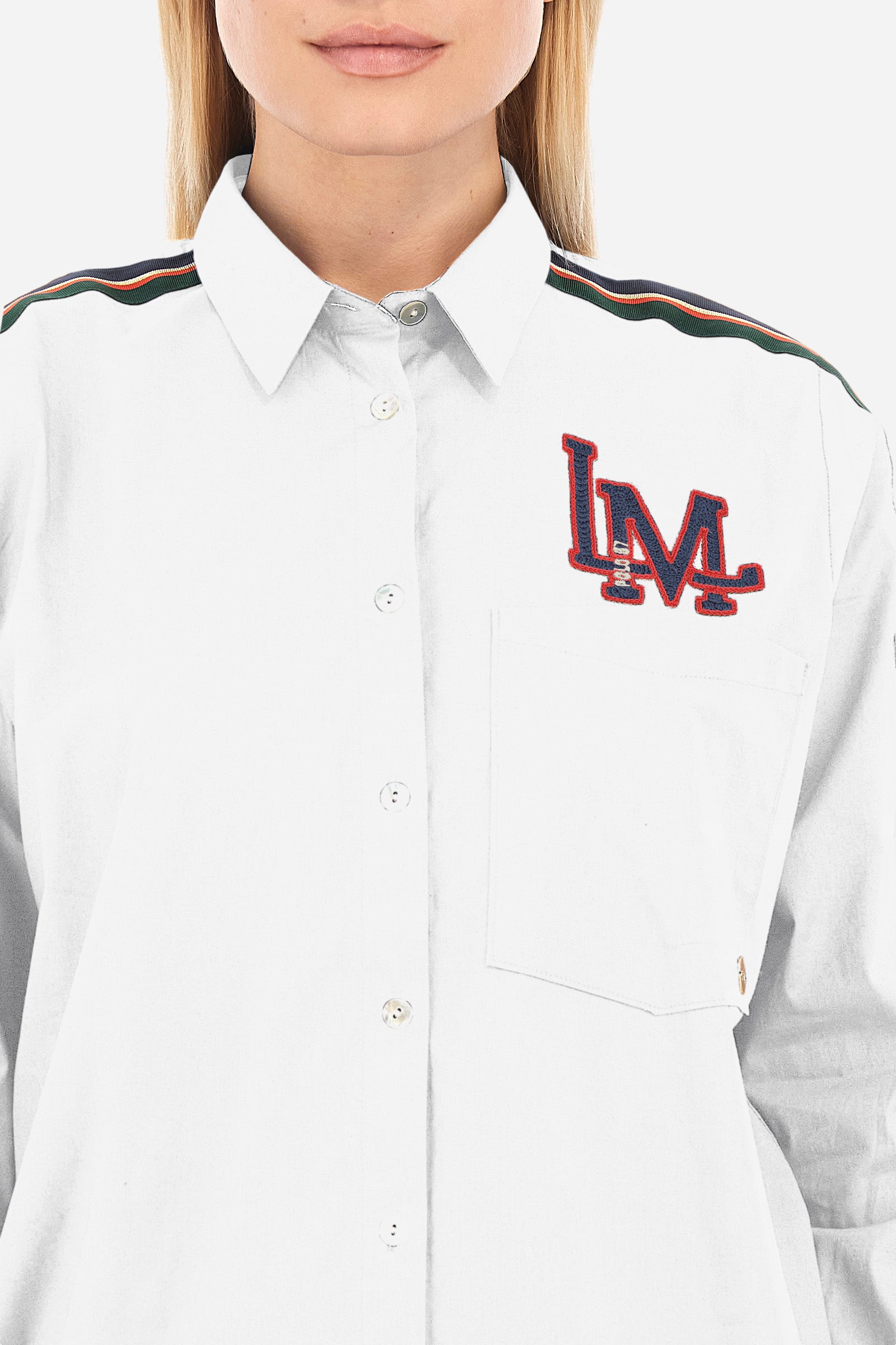 Solid-coloured long-sleeved women's shirt, made of stretch cotton with a regular fit. The line is Polo Academy and features a classic collar with button fastening. The chest is embellished with the LM patch and on the shoulders there is a contrasting band applied with a final ring. Finally, the shirt has a front pocket for added practicality. The model is 174 cm tall and wears a size 2. - Optic White