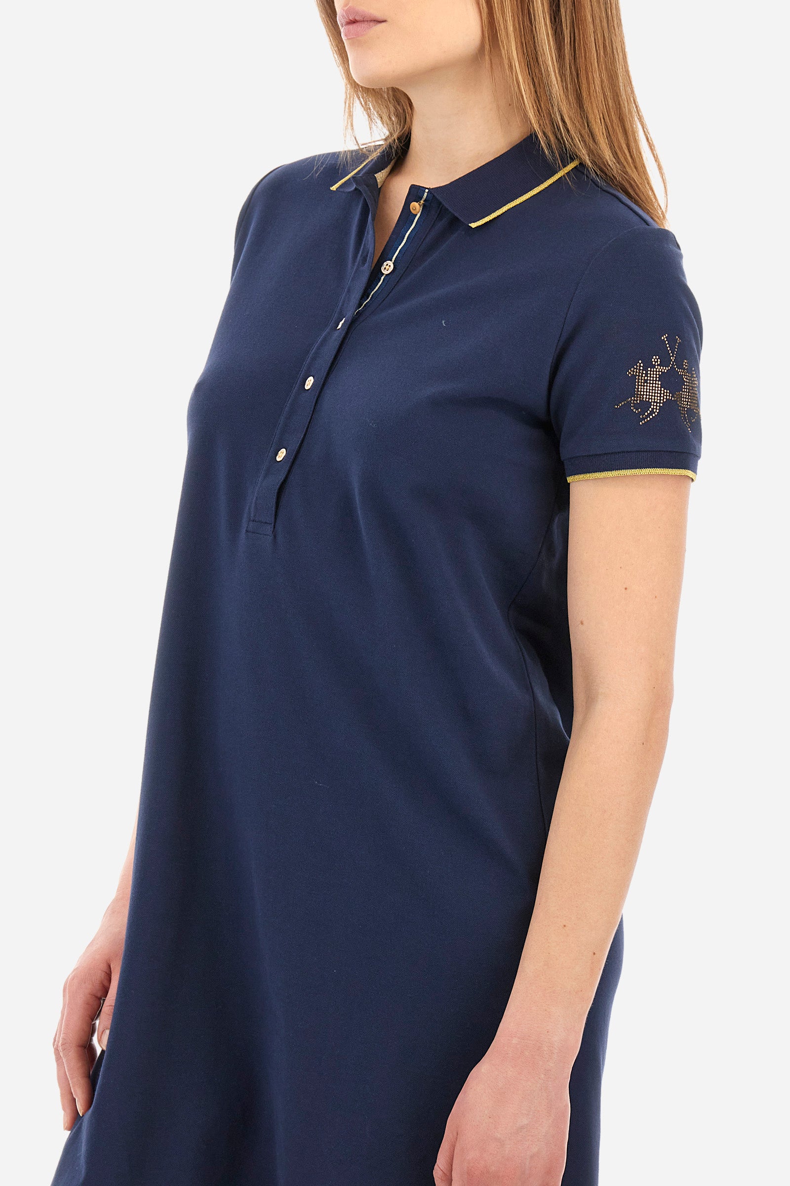 Single-colour short-sleeved dress made of elasticated cotton. Soft, straight cut silhouette, above-the-knee length. With a profiled and ribbed collar and armholes. Collar with contrasting rhinestone writing. With button fastening. The "La Martina" lettering can be found under the collar. A rhinestone logo is applied on one of the sleeves. The fit is regular. The model wears a size 2. - Navy