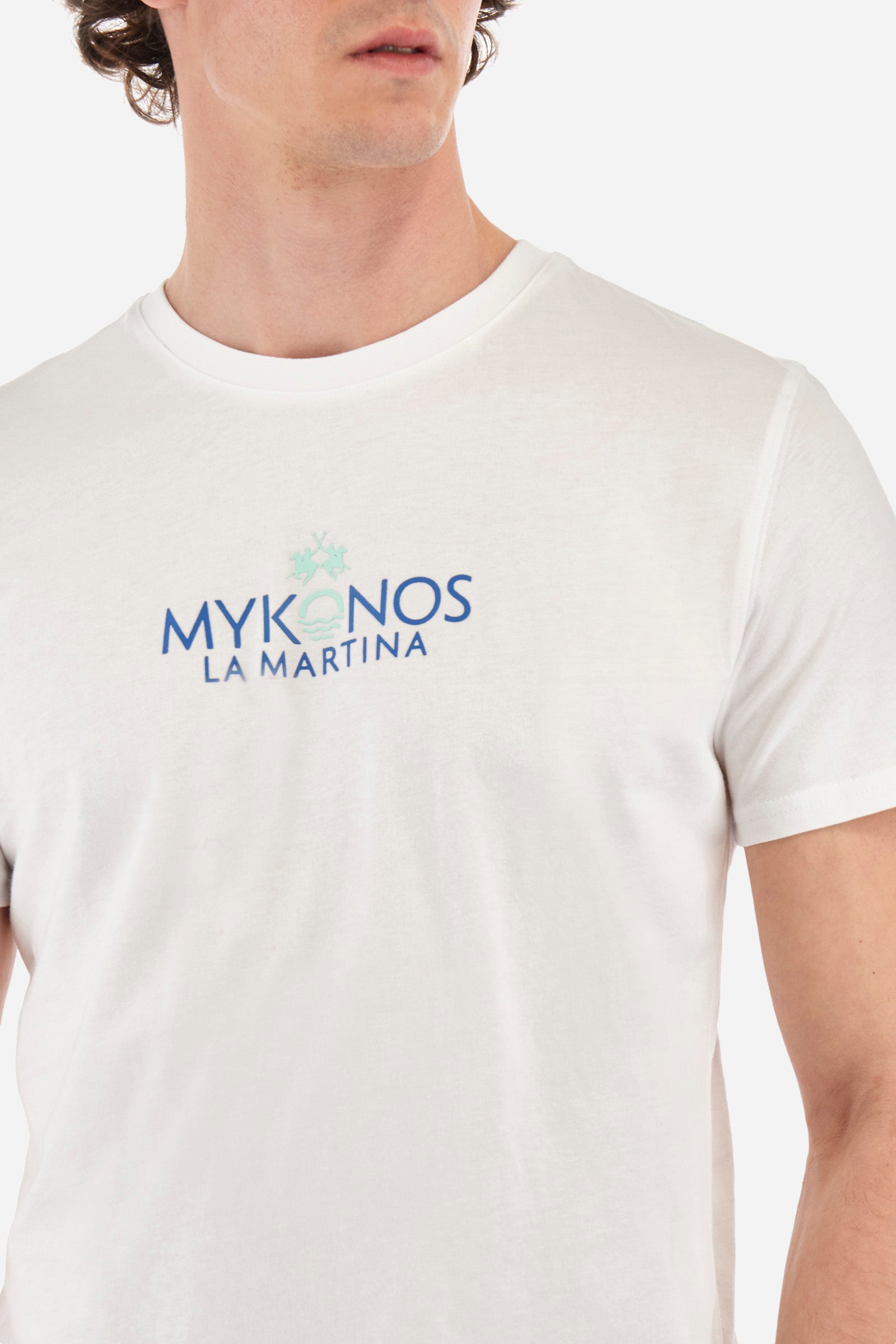 Men's short-sleeved T-shirt with a crew neck in a single colour. Made of 100% cotton. Printed on the front are the words "Mykonos" and "La Martina". On the back we find stylised prints inspired by Greece and the lettering that is also present on the front. Regular fit. The model wears a size L. - Optic White