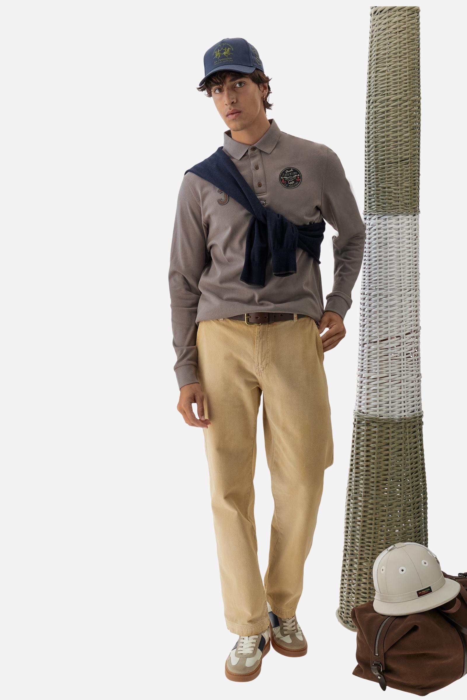 Long-sleeve polo shirt crafted from 100% high-quality cotton jersey. The velvety fabric offers a warm, cozy feel, perfect for cooler seasons. Ribbed collar and cuffs in matching tone, with a three-button personalized placket. A small multicolor embroidered logo sits below the opening, while tonal patches in different shapes and textures, inspired by Argentine culture and Gaucho tradition, decorate the chest and back. Classic regular fit. Model wears size L. - Falcon