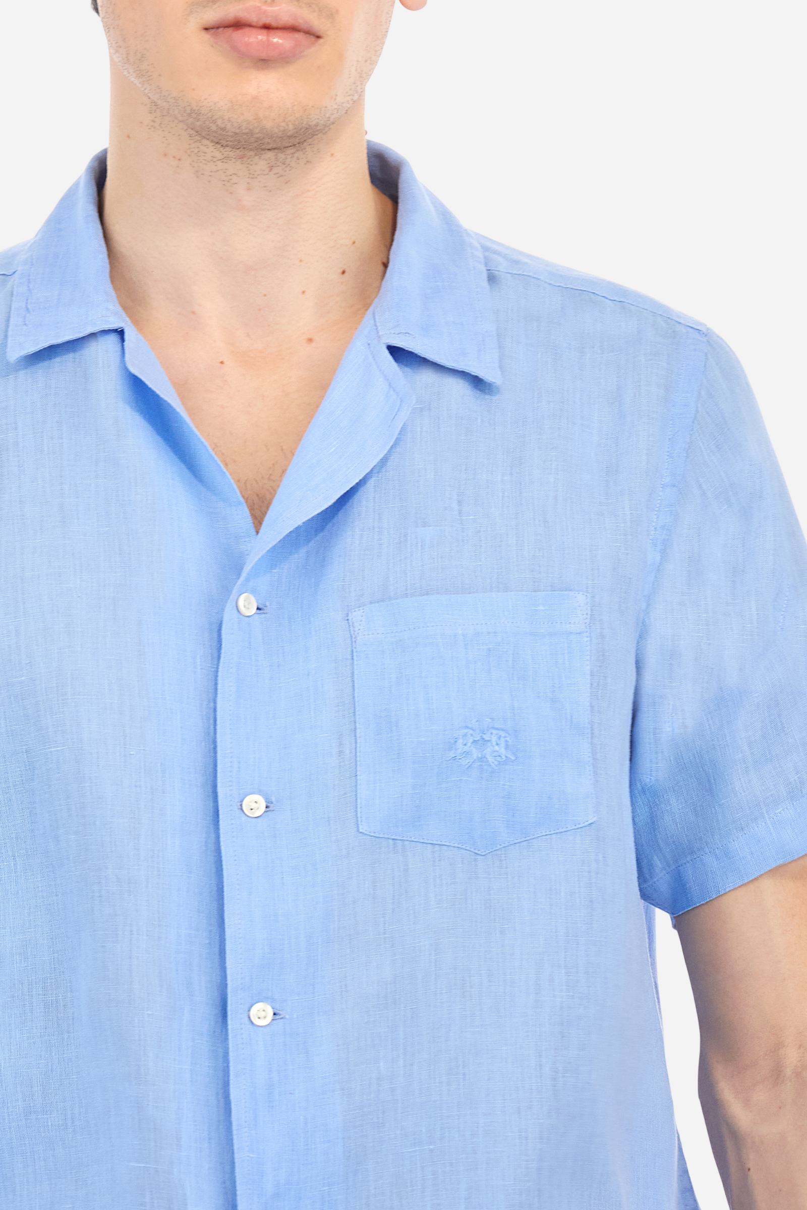 Men's plain short-sleeved shirt made from soft linen canvas. This model features a bowling collar and an appliquéd patch pocket on the left side of the chest, topped with a tone-on-tone embroidered logo. Regular fit. The model is wearing a size L. - Vista Blue