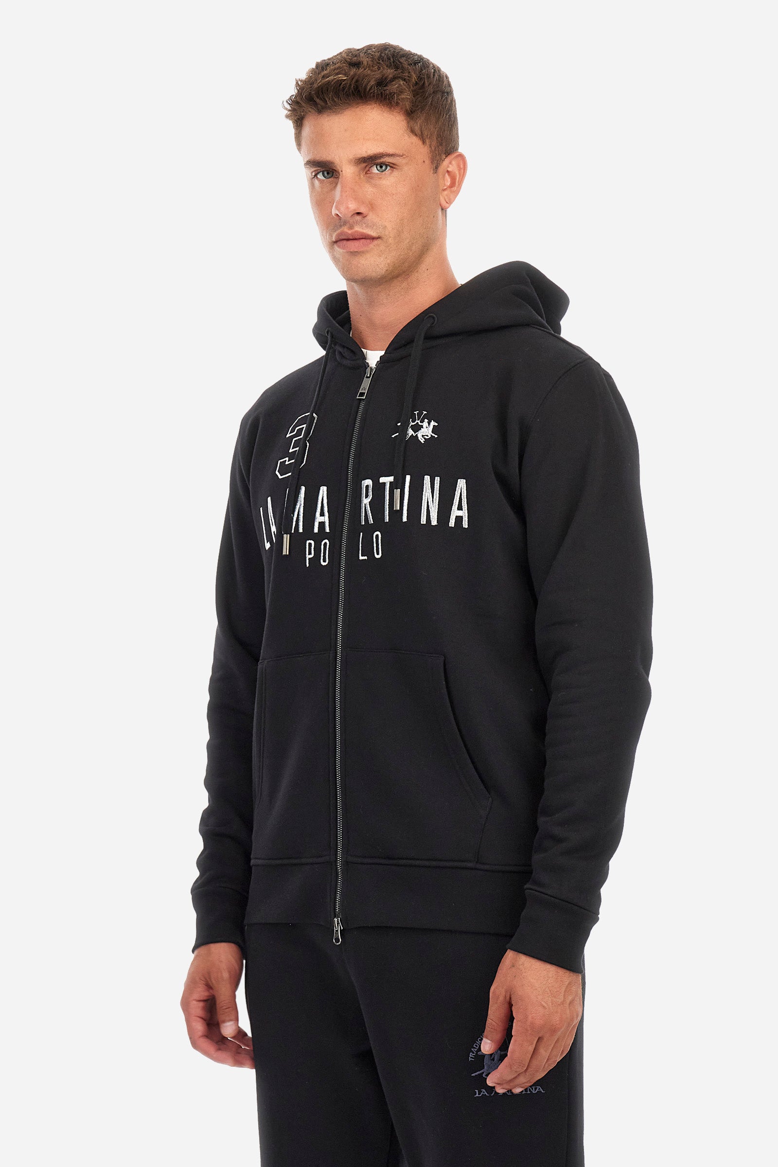 Men's long-sleeved single-colour sweatshirt with a hood in 100% cotton. Hood with drawstring. Double front pocket. Ribbed cuffs and hem. The logo, the La Martina lettering and the number three are embroidered in contrast on the front. Regular fit. The model is wearing a size L. - Black