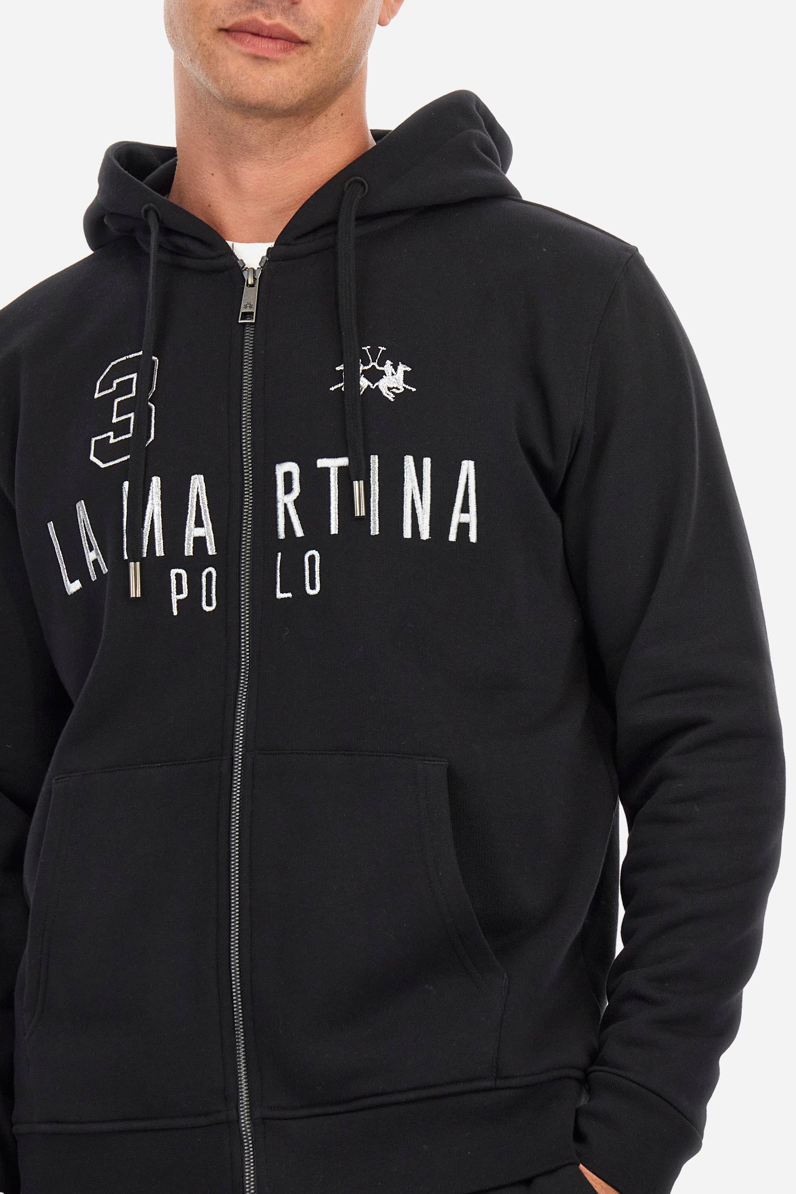 Men's long-sleeved single-colour sweatshirt with a hood in 100% cotton. Hood with drawstring. Double front pocket. Ribbed cuffs and hem. The logo, the La Martina lettering and the number three are embroidered in contrast on the front. Regular fit. The model is wearing a size L. - Black