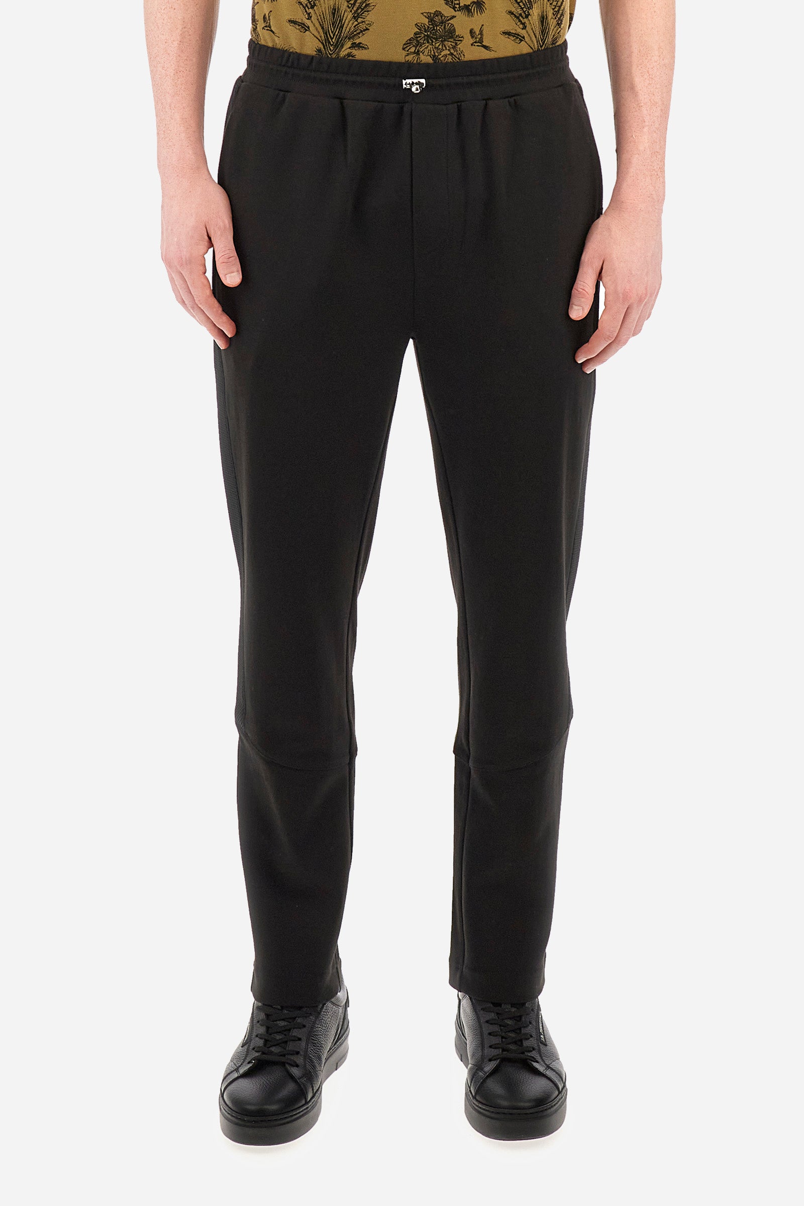 Men's single-colour jogging bottoms in mixed cotton. Drawstring at the waist and double welt pocket on the front. Featuring a side stripe with a honeycomb texture. On the back there is a single open pocket featuring the brand's initials. The fit is regular. The model wears a size L. - Black