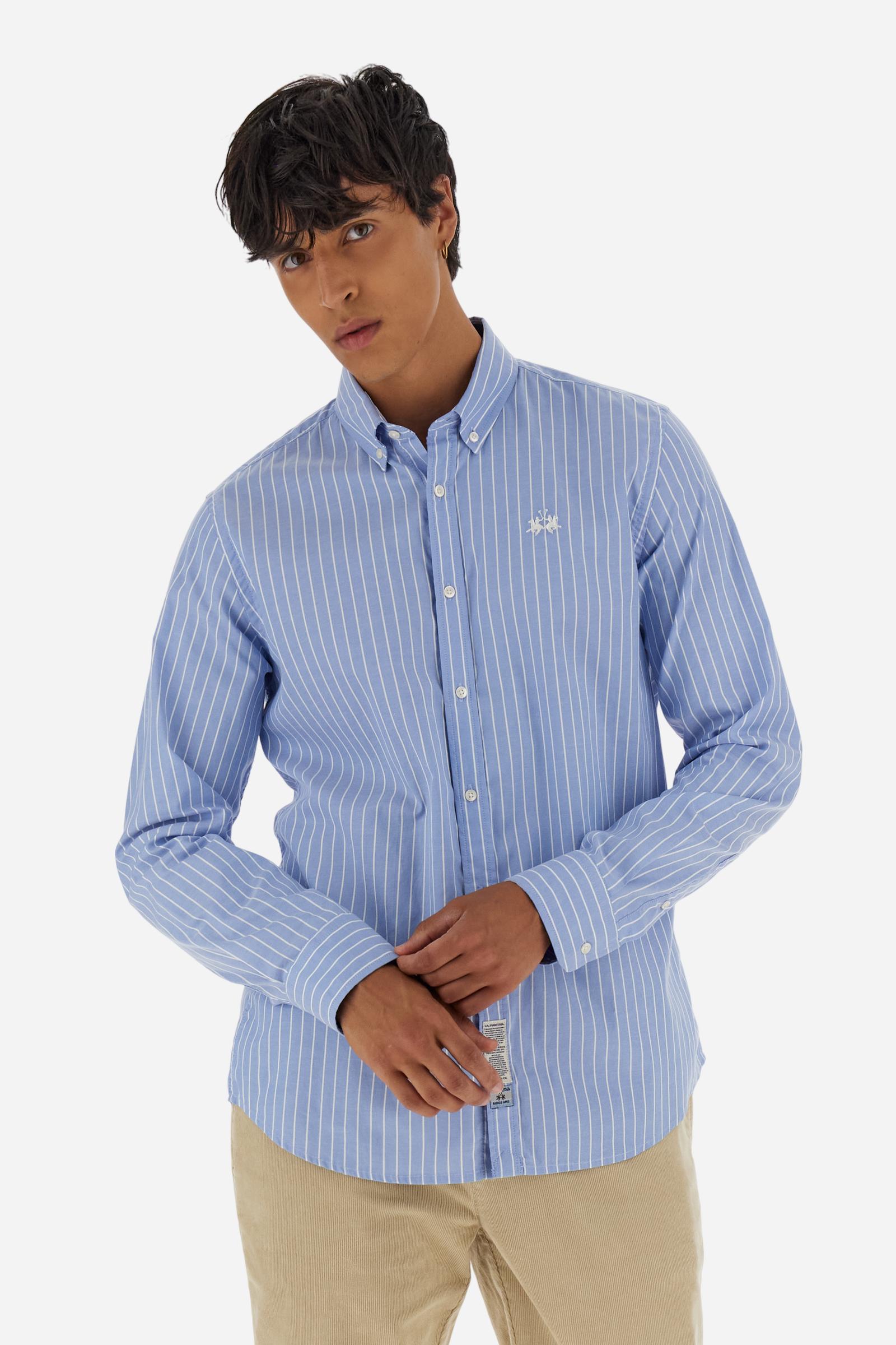Men's long-sleeved light blue cotton Oxford shirt with fine white stripes. Button-down collar with contrasting interior details and the distinctive “Argentina Signature”. Discreet contrasting logo embroidery on the chest completes the design. Regular fit. Model wears size L. - Cornflower Blue/Op.W