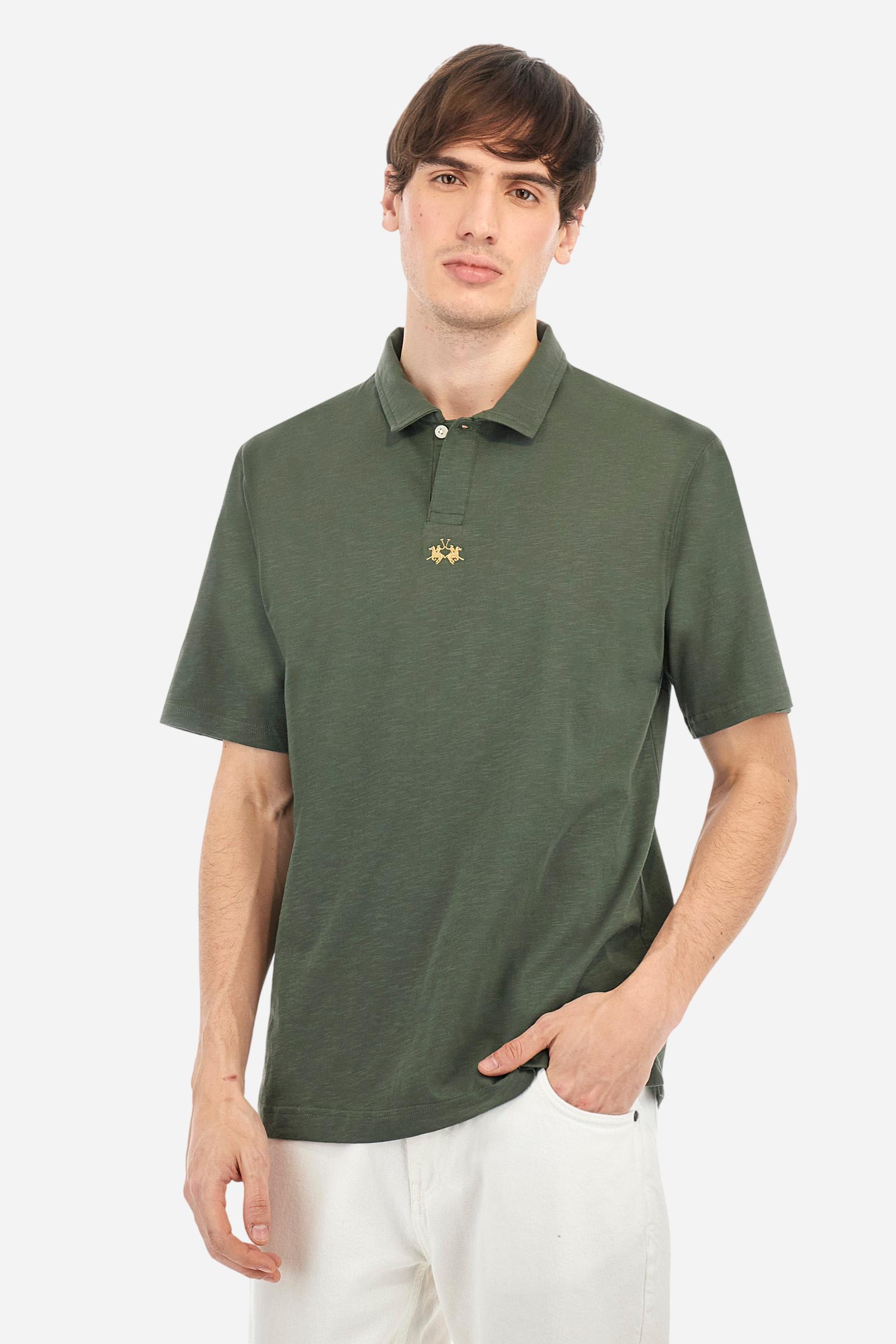 Men's short-sleeved polo shirt in a single colour, made of 100% cotton slub jersey. Fastens with a button. A fabric patch representing the garment's certificate is sewn onto the back. The logo is embroidered in contrast under the opening on the front. Comfort fit. The model is wearing a size L. - Thyme