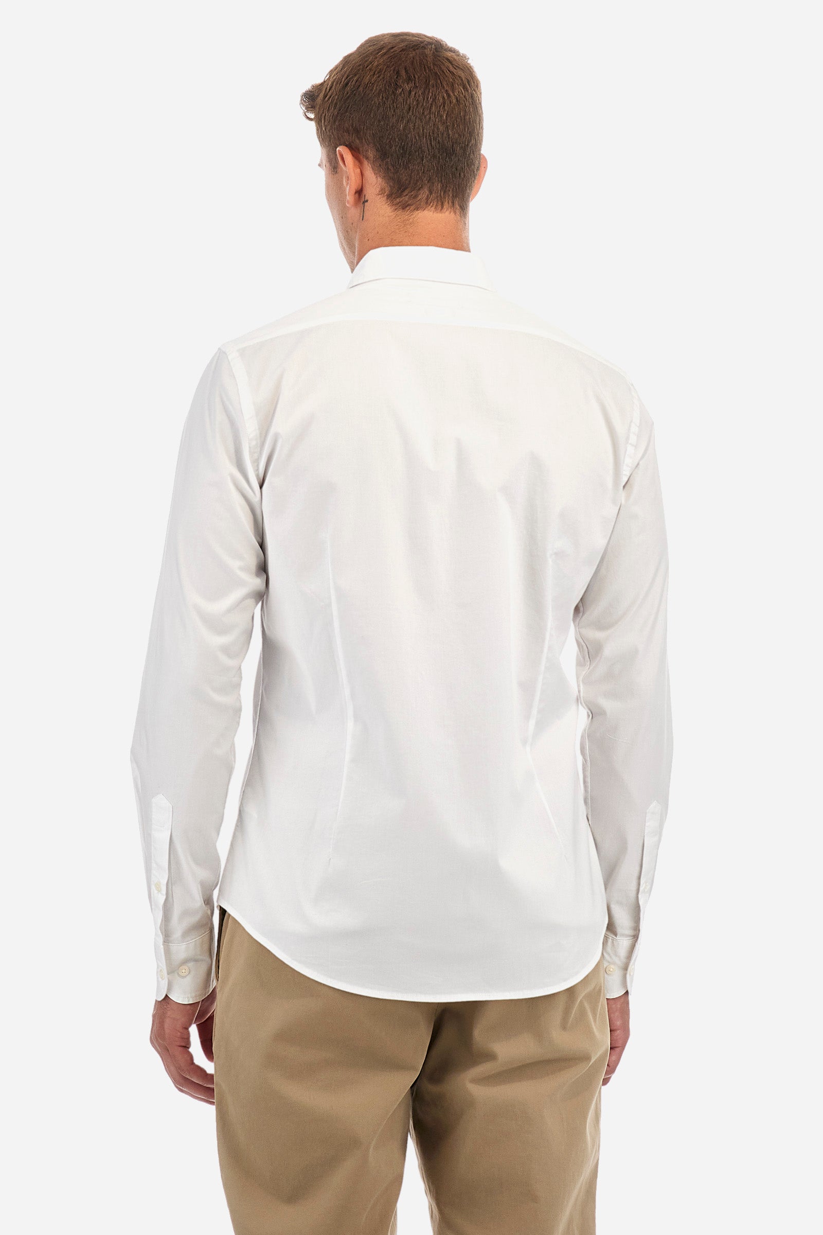 Men's single-colour shirt with long sleeves, made of stretch cotton. Button-down collar. With buttoned cuffs. Featuring a small embroidered logo on the front. Slim fit. The model is wearing a size L. - Optic White