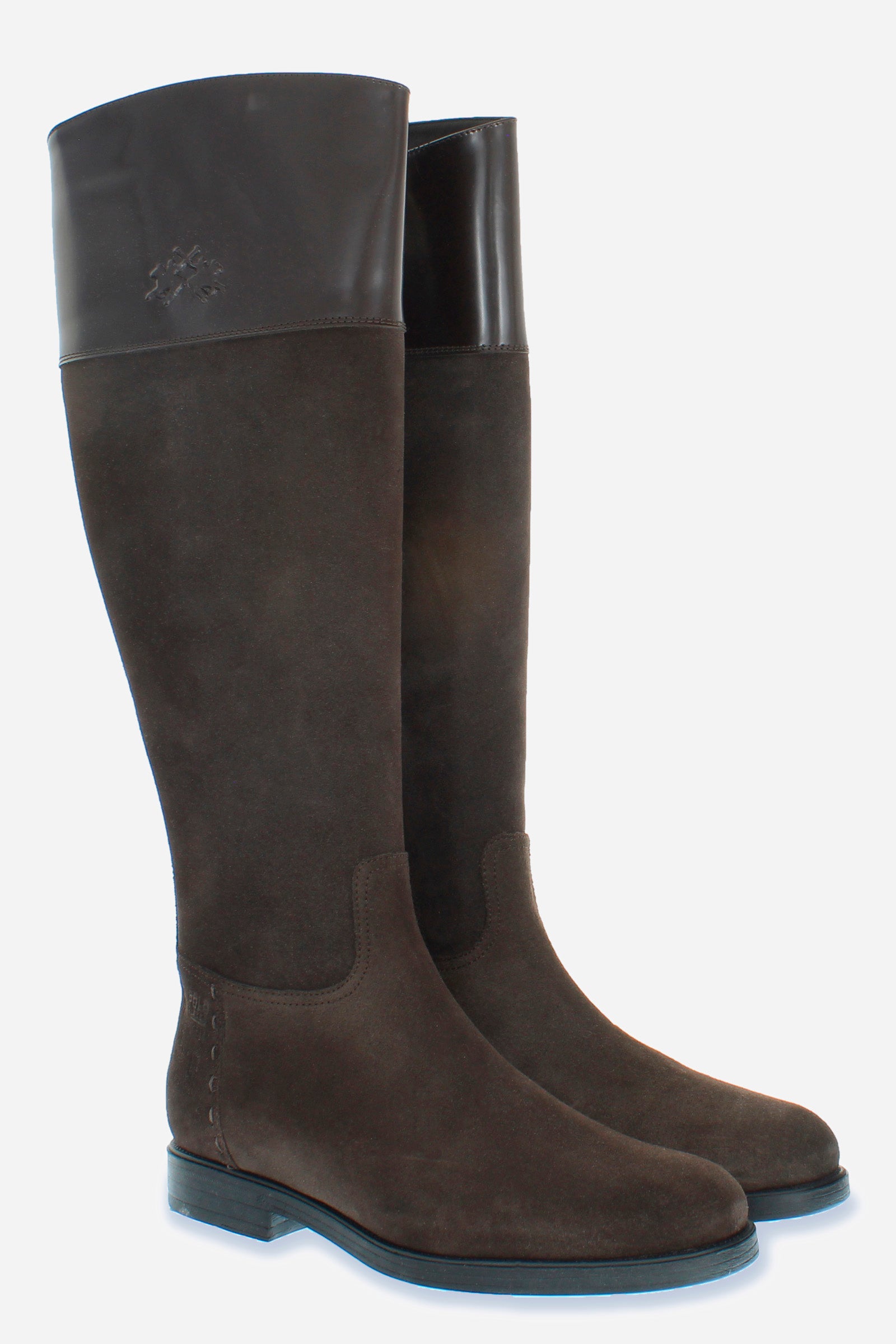 A clean-cut, equestrian-inspired women's boot in suede with soft cowhide at the top of the boot leg.An emblematic model with the unique savoir-faire of La Martina. The horse logo is embossed on the side upper leg. Customised metal rivet detailing on the lower side. This is complemented by the craftsmanship of the hand-stitching. With an extremely versatile and current country chic style. - DARK BROWN