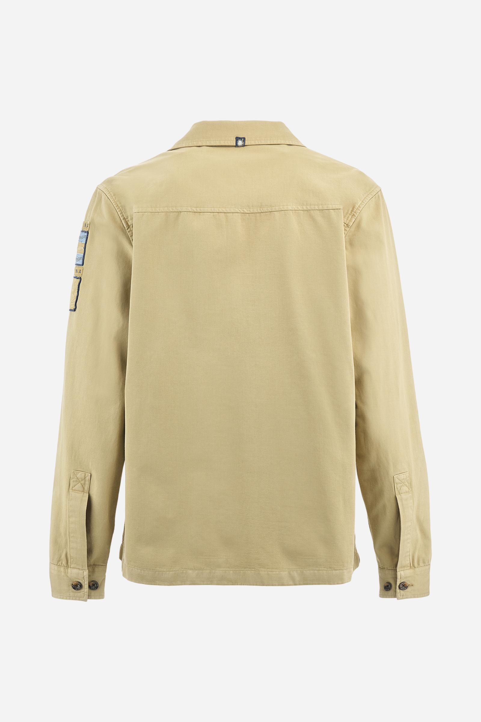 Men's single-colour long-sleeved overshirt made of 100% cotton slub twill. Bowling collar and jacket opening with inside placket, fastening with imitation horn buttons.On the shoulder and chest the embroidery is in tone with the garment, Argentina lettering embroidered on one shoulder. There are several patches applied on the left sleeve. A tone-on-tone logo is embroidered on the front. Regular fit. The model is wearing a size L. - Twill