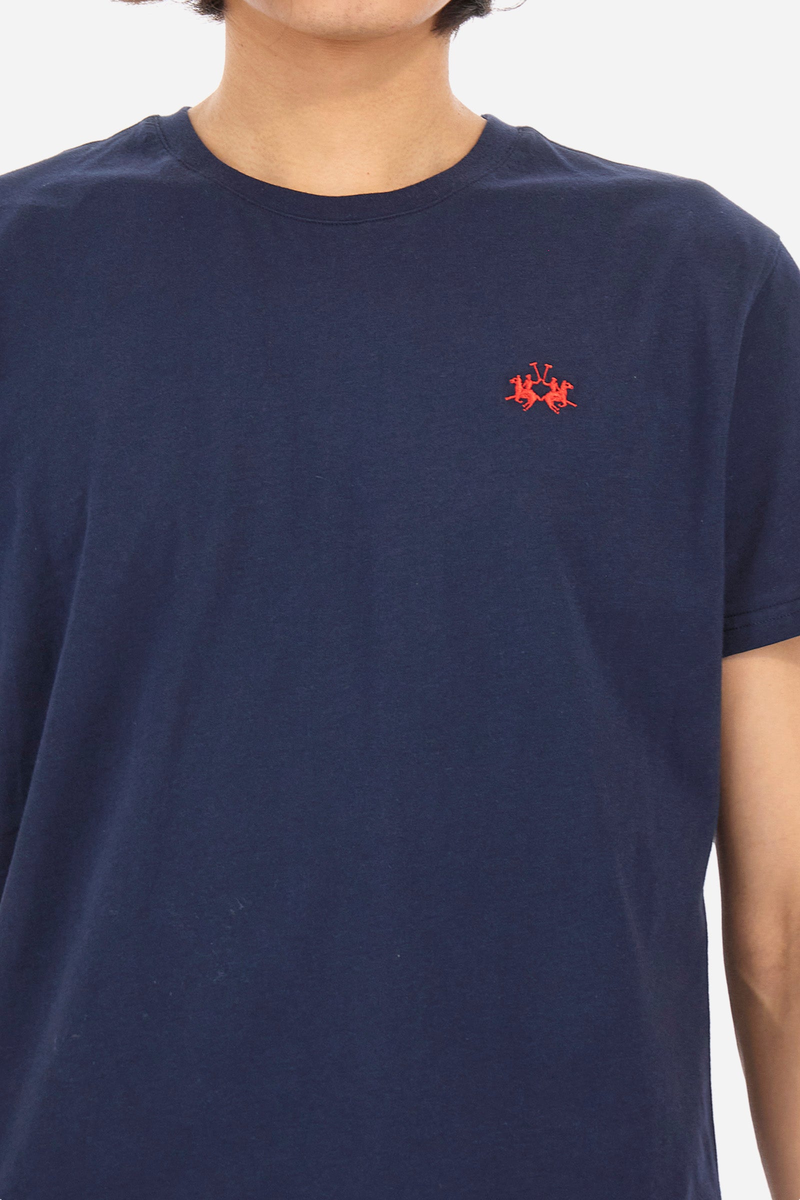 Men's short-sleeved crew-neck T-shirt in solid colour with embroidered logo in contrasting colour on the chest. Made of 100% cotton with a regular fit. It is perfect paired with Bermuda shorts or trousers for a casual and trendy look. Suitable for leisure time. The model is 187 cm tall and wears a size L. - Navy
