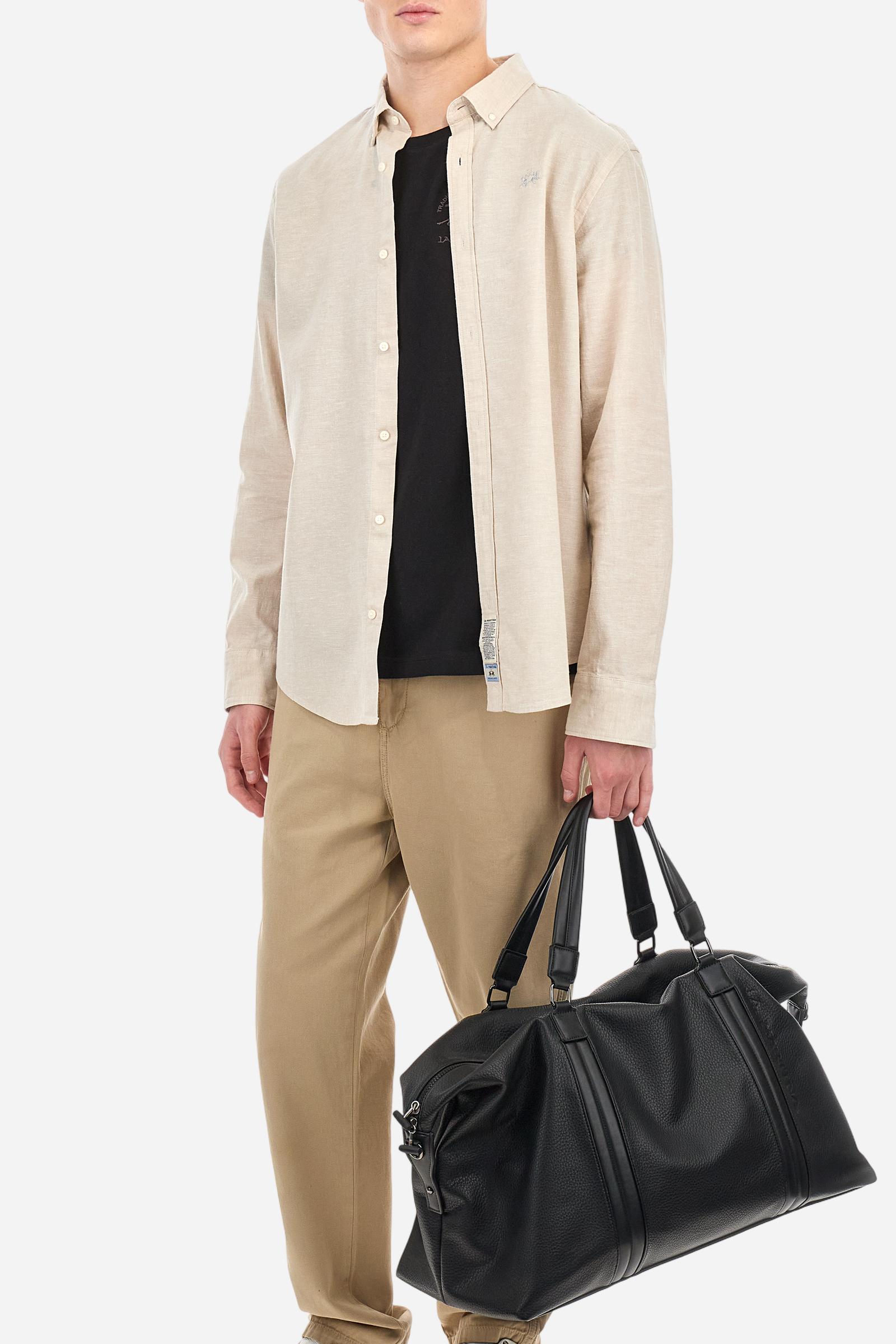 Men's plain long-sleeved shirt made from linen canvas. It features a button-down collar and a basic, traditional design, with woven labels at the bottom of the opening. The logo is embroidered on the chest, over the heart, in tone-on-tone thread. Regular fit. The model is wearing a size L. - Rainy Day