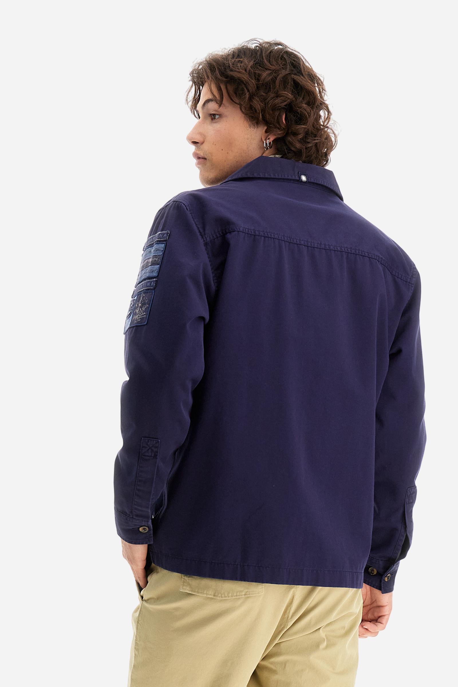 Men's single-colour long-sleeved overshirt made of 100% cotton slub twill. Bowling collar and jacket opening with inside placket, fastening with imitation horn buttons.On the shoulder and chest the embroidery is in tone with the garment, Argentina lettering embroidered on one shoulder. There are several patches applied on the left sleeve. A tone-on-tone logo is embroidered on the front. Regular fit. The model is wearing a size L. - Deep Cobalt