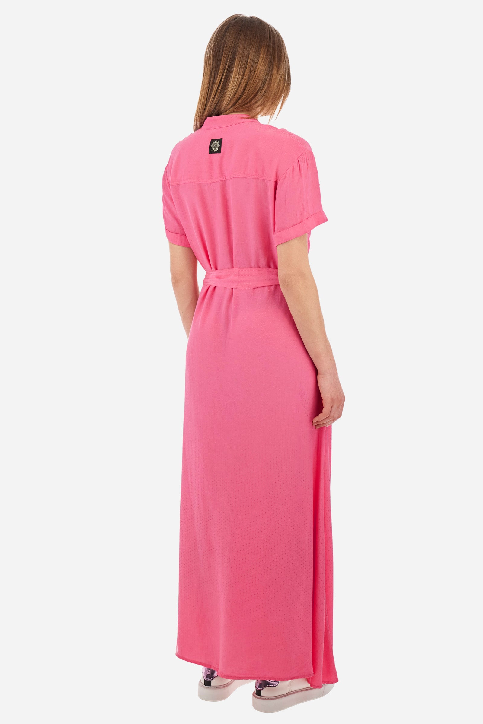 Women’s dress with short sleeves in solid color with bright tone on tone details. Made of synthetic viscose satin fabric. Silhouette straight cut and soft, long to the feet. Waist marked by the belt supplied with the head. V-neck and stand-up collar. Closure with buttons that reach up to the end of the dress. Presence of two fake pockets with buttons on the chest. The patch applied on the back with the representative symbol of the Guards line. The fit is regular. The model wears an IT40 size. - Hot Pink