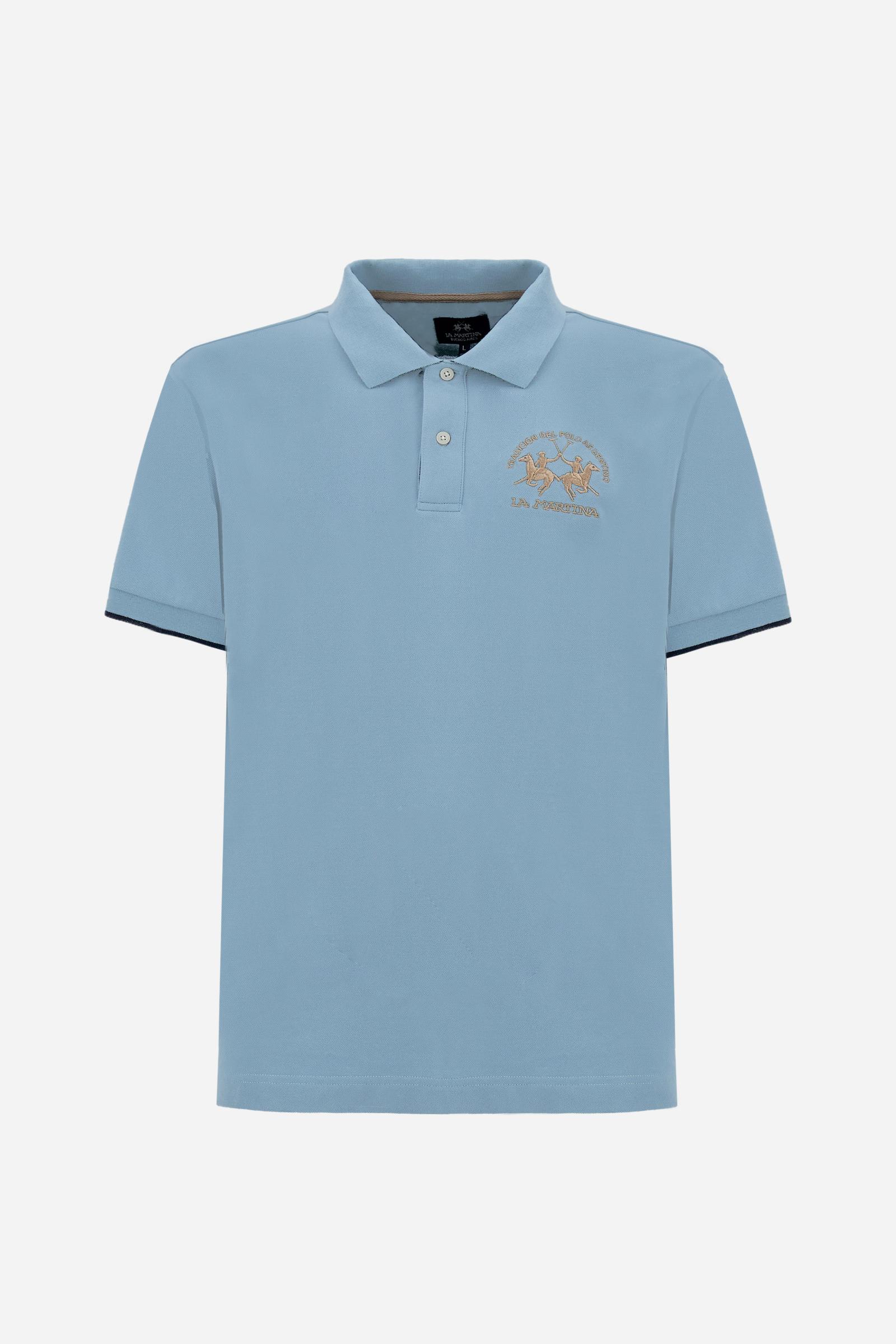 Men's short-sleeve polo shirt made from solid-color stretch piqué fabric. The model features a two-button front placket with ribbed collar and cuffs in matching tone. An iconic design of the brand, it stands out for the large embroidered team logo in contrasting color on the chest and the bold brand print under the collar in contrasting color. The regular fit ensures comfort and versatility for everyday wear. The model is wearing size L. - Stone Blue