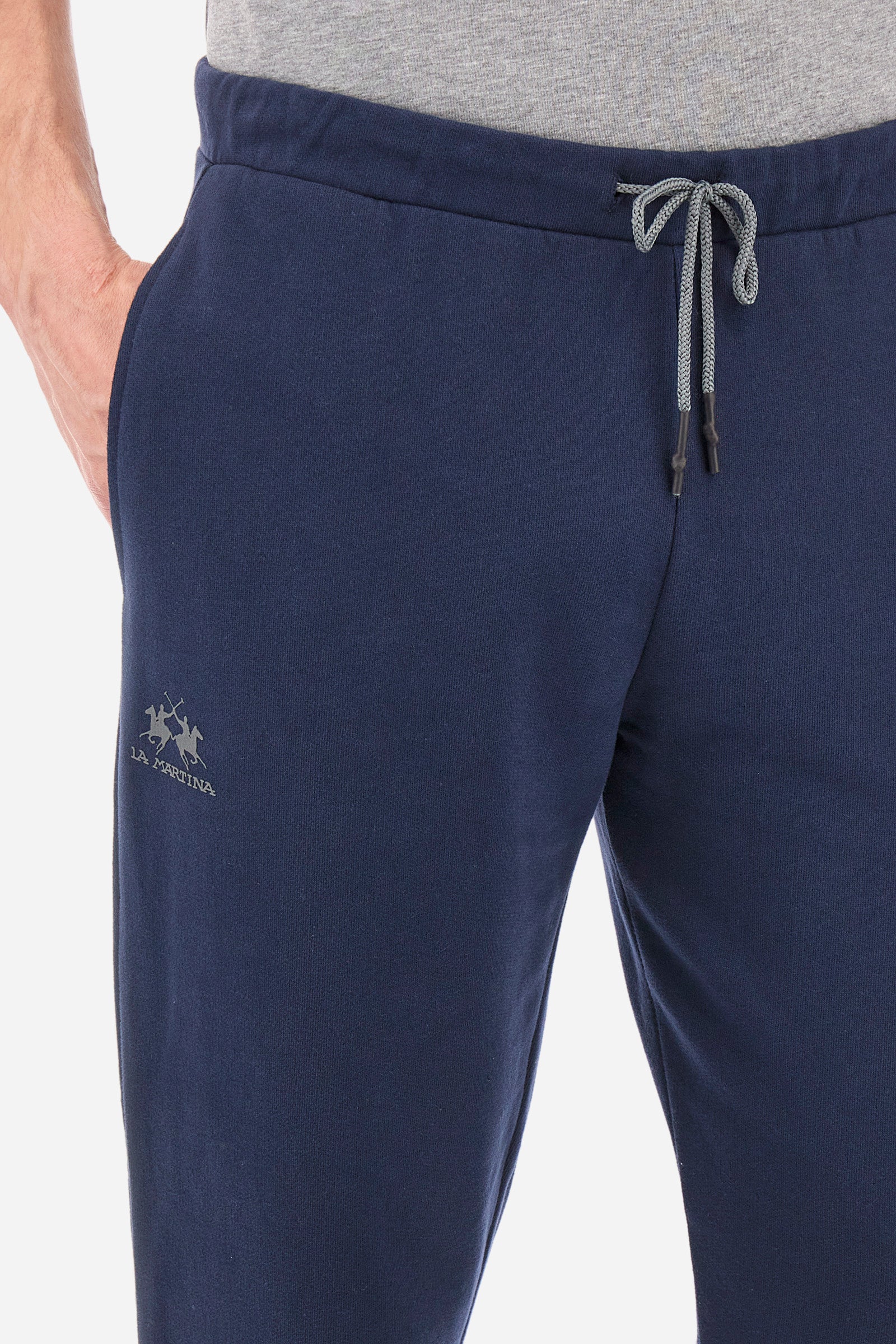 Men's jogging trousers with a logo print on the pocket in a regular fit. Features a drawstring waist, side pockets and back pocket. Made of 100% cotton with a regular fit, a must-have item in your wardrobe for the gym or leisure time. Very easy to combine with a sweatshirt or T-shirt. The model is 187 cm tall and wears a size L. - Navy