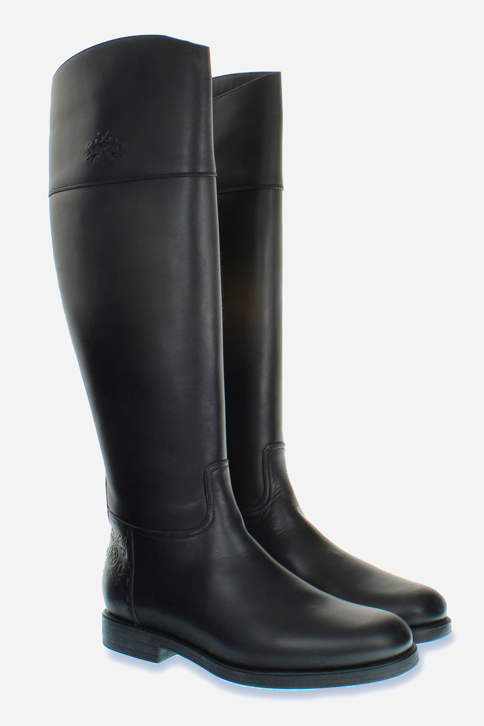 Equestrian-inspired women's boot in soft cowhide with a clean style.An emblematic model with the unique savoir-faire of La Martina. The horse logo is embossed on the side upper leg. Customised metal rivet detailing on the lower side. This is complemented by the craftsmanship of the hand-stitching. With an extremely versatile and current country chic style. - BLACK