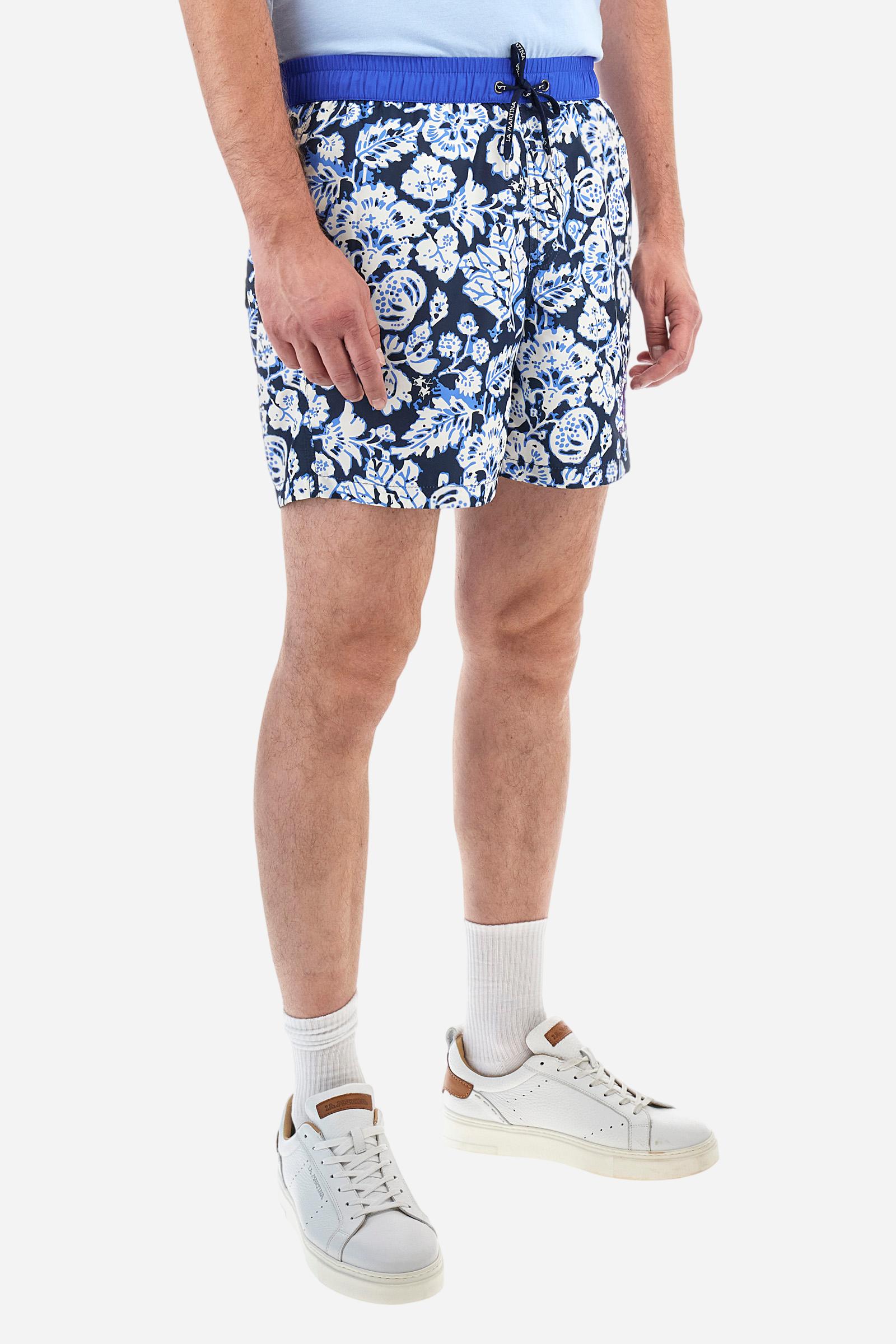 Men's swimming shorts, made of printed nylon. The stylised floral pattern is an exclusive design. The plain nylon elastic waistband has a custom drawstring inside for waist adjustment. On the inside of the shorts is an elasticated mesh brief. Featuring double side pockets on the hips and patch pocket with contrasting coloured flap on the back. The large logo is embroidered on the bottom of the left leg, on the front. Regular fit. The model is wearing a size L. - Navy/Dazzling Blue