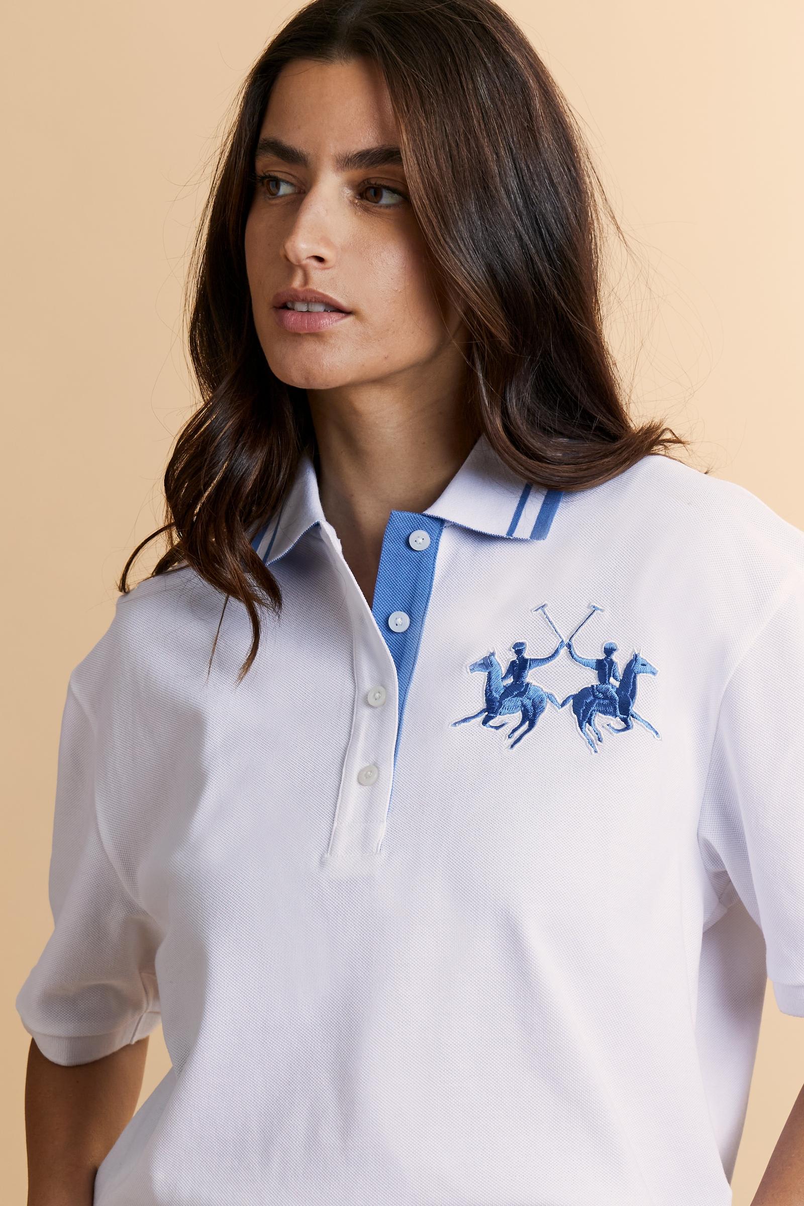 Women's short-sleeve polo shirt made from 100% cotton piqué fabric in solid color. The model features a front opening with customized buttons and a contrasting inner placket. The ribbed collar is two-tone with a striped detail creating a positive/negative color effect between the upper and lower parts. The modern fit features a slightly boxy cropped cut. The chest is decorated with a maxi 3D embroidered logo in contrasting color. The model is wearing size 2. - Optic White