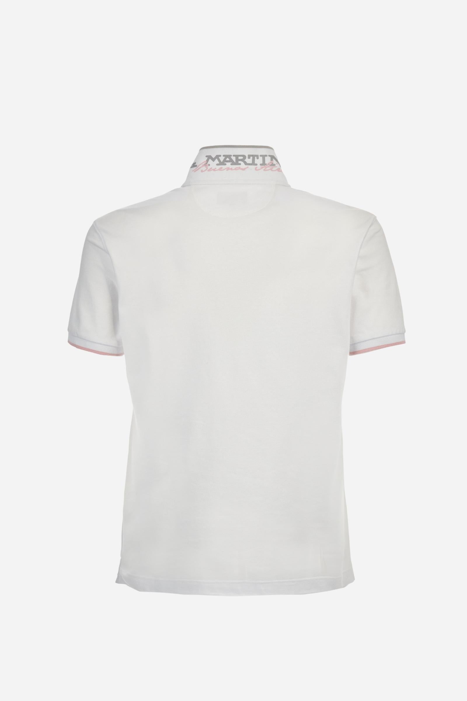Short-sleeved, single-colour men's polo shirt made of stretch cotton piqué. Fastens with two buttons. The collar and cuffs are ribbed, and there is a colour-contrasting trim at the bottom of the collar. Inside the collar there is a grosgrain ribbon of a different shade. The logo is embroidered on the chest in a contrasting colour. The fit is slim. The model is wearing a size L. - Optic White