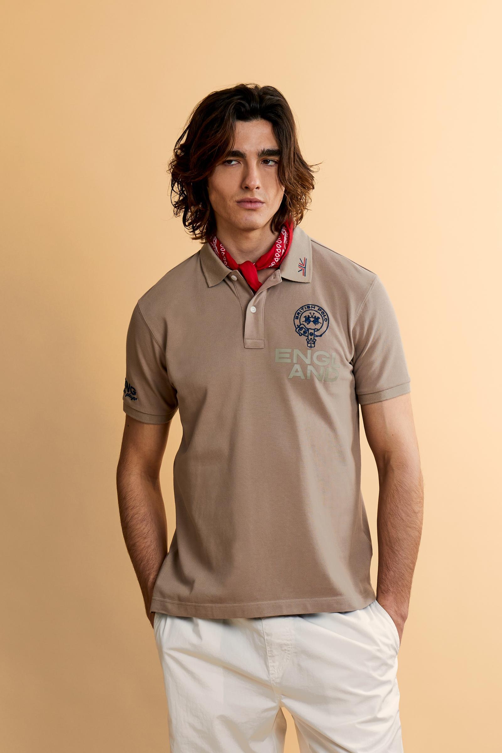 Men’s short-sleeve polo in solid 100% cotton piqué. Regular fit with matching ribbed details. Part of the “Nations” collection celebrating countries of the World Polo Tour through embroidered and printed graphics. Small contrast logo on the chest. The model wears size L. - Humus