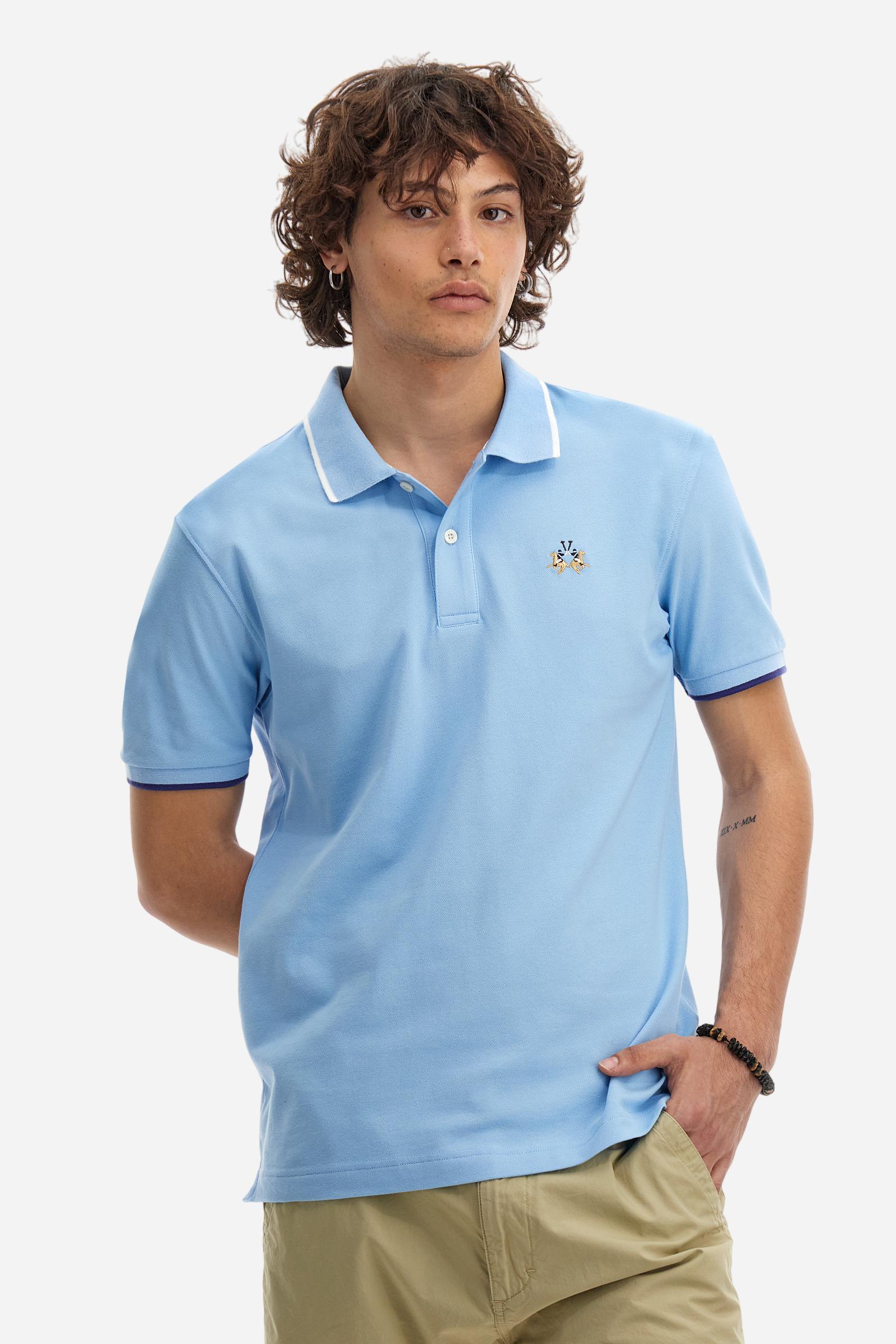 Short-sleeved, single-colour men's polo shirt made of stretch cotton piqué. Fastens with two buttons. The collar and cuffs are ribbed, and there is a colour-contrasting trim at the bottom of the collar. Inside the collar there is a grosgrain ribbon of a different shade. The logo is embroidered on the chest in a contrasting colour. The fit is slim. The model is wearing a size L. - Vista Blue