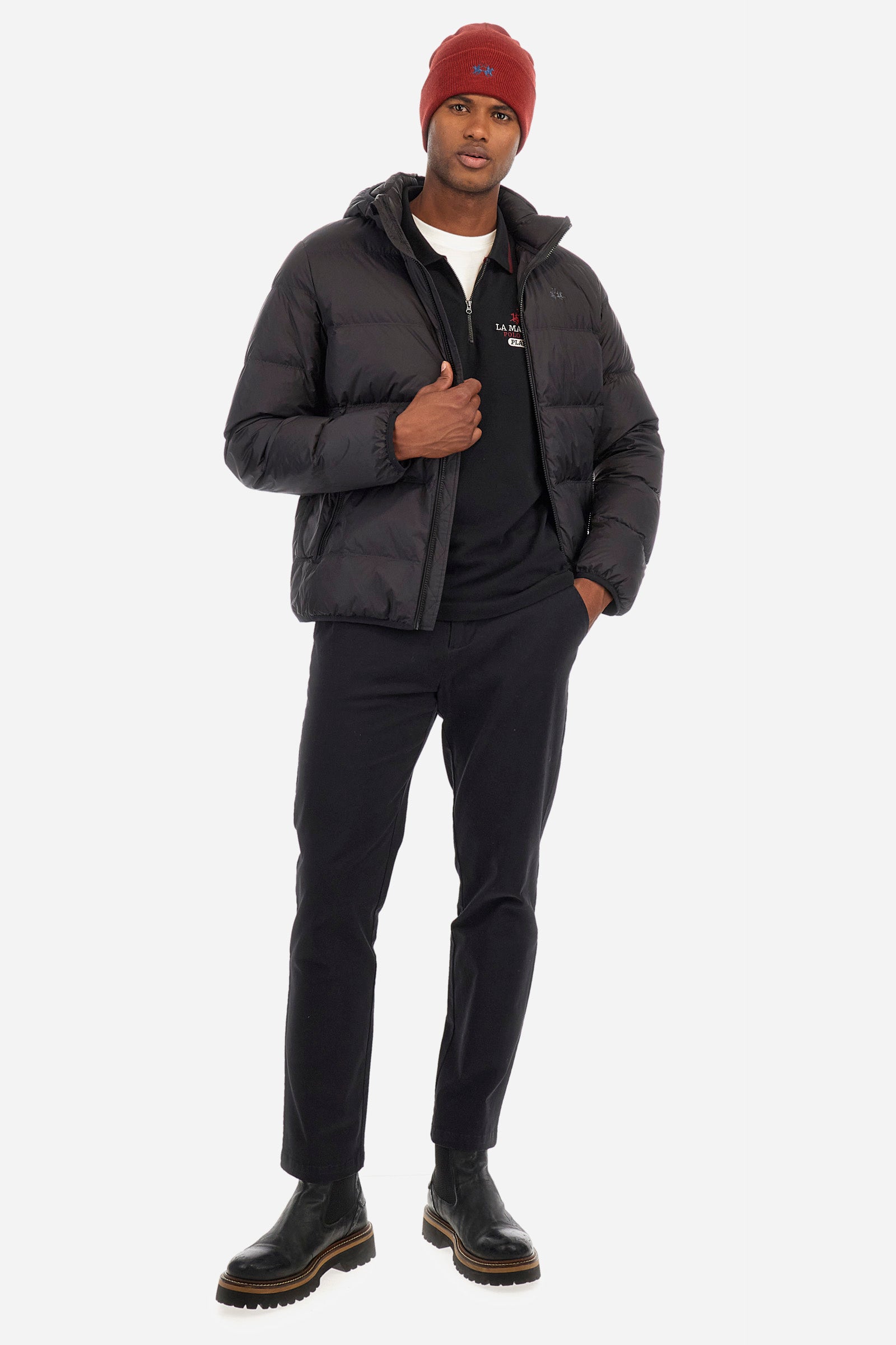 Men's plain short-sleeved polo shirt, made from 100% cotton. Half-zip fastening. Trimmed collar. The sleeves are finished with contrasting stripes. The symbols and lettering associated with the Harvard line are appliquéd on the back. The front is embroidered with the logo and La Martina lettering. Regular fit. The model is wearing a size L. - Black