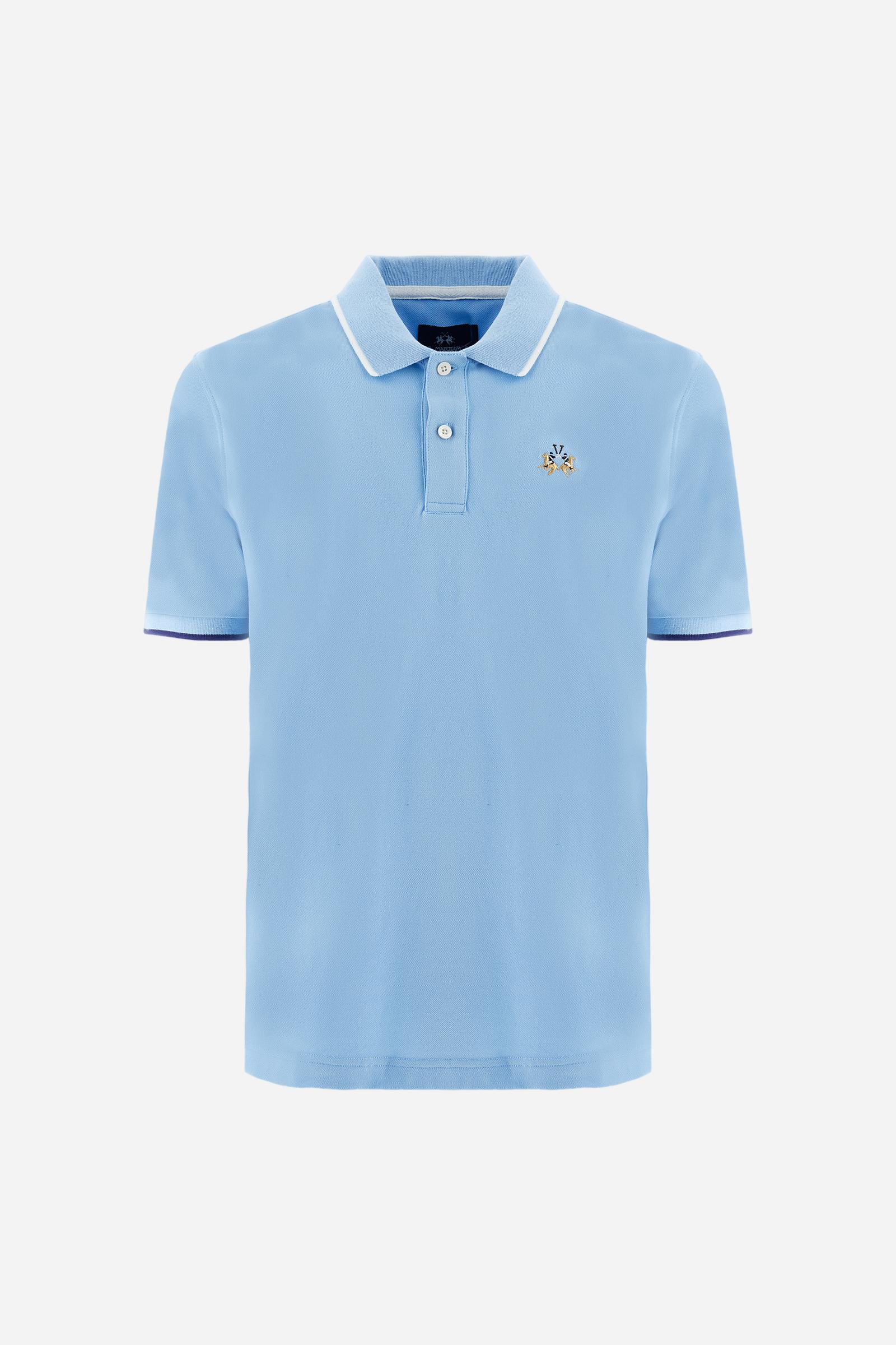 Short-sleeved, single-colour men's polo shirt made of stretch cotton piqué. Fastens with two buttons. The collar and cuffs are ribbed, and there is a colour-contrasting trim at the bottom of the collar. Inside the collar there is a grosgrain ribbon of a different shade. The logo is embroidered on the chest in a contrasting colour. The fit is slim. The model is wearing a size L. - Vista Blue