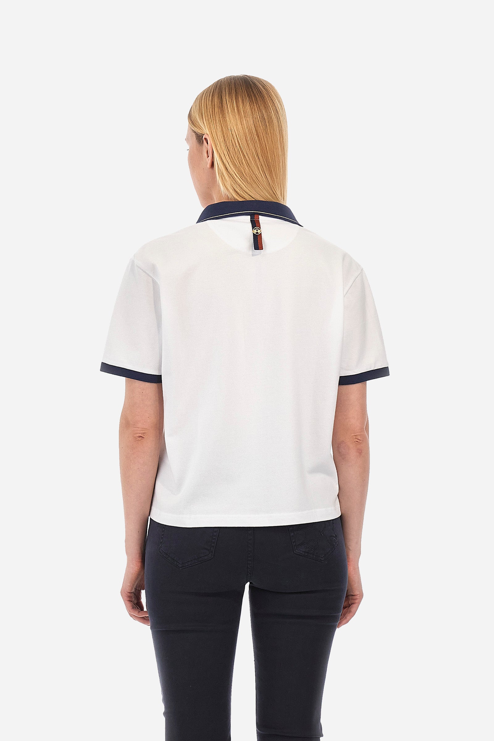 Women’s polo with short sleeves in solid color with contrasting details of the Academy Polo line. Made of stretch cotton. V-neck and armhole hem in contrasting shades. Single button closure. Ribbed neckline, collar and armhole. On the back is sewn the name and logo of the brand. On the back there is a metal plate with the logo applied on a colored strip. The fit is regular. The model wears a size 2. - Optic White