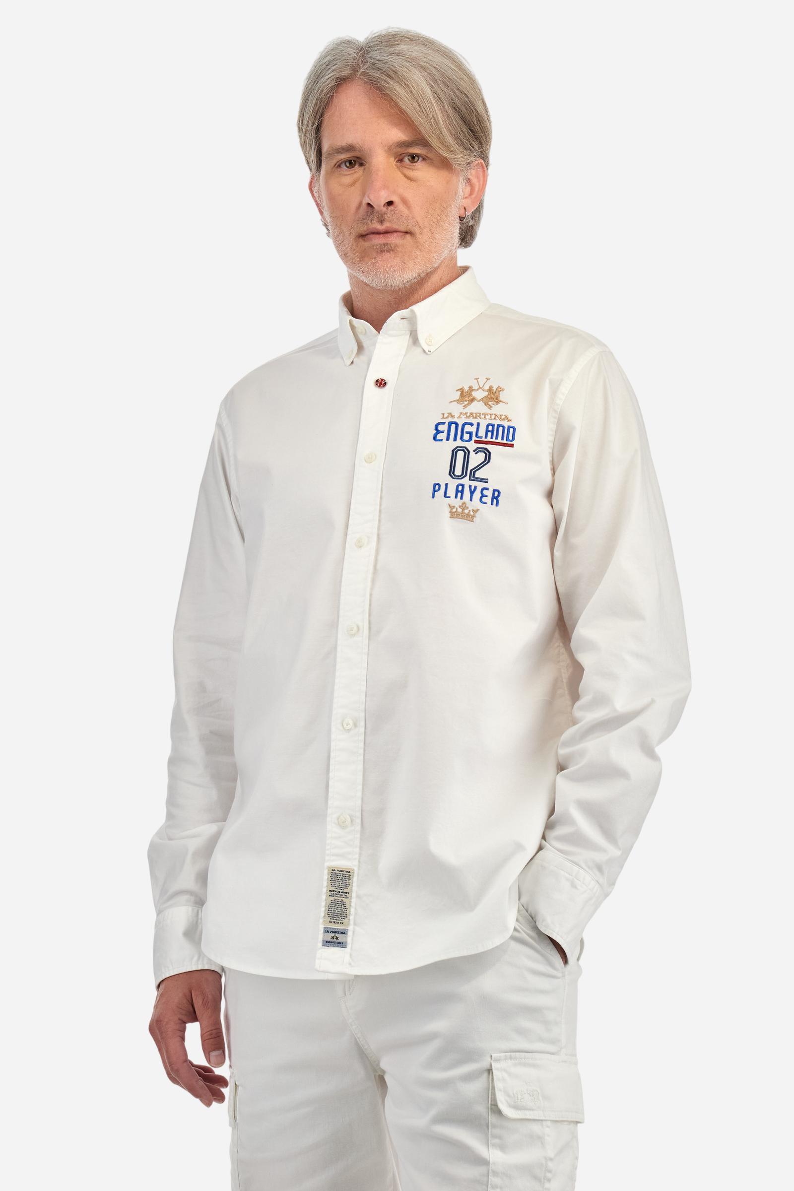 Men's long-sleeved plain shirt made from 100% Oxford cotton. The button-down collar is finished with a second button printed with the English flag. The multicoloured embroidery on the chest, over the heart, includes lettering, numbers and the logo, which add a distinctive touch. Regular fit. The model is wearing a size L. - Optic White