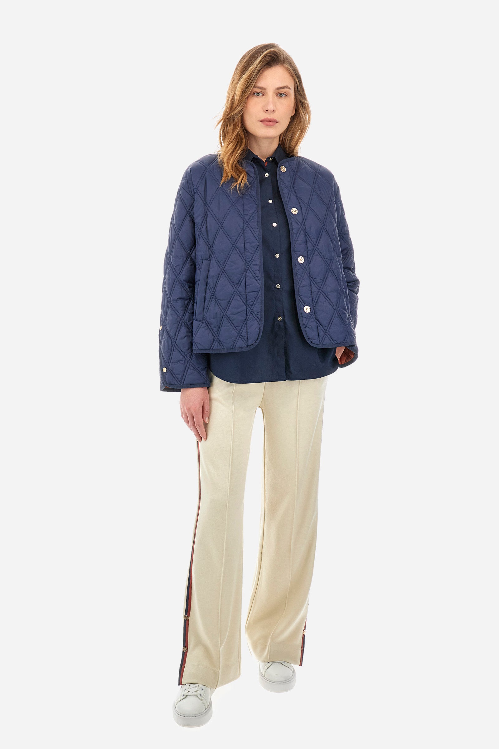 Women's long-sleeved patterned shirt in a single colour from the Polo Academy line. Made of stretch cotton. The internal part of the fastening features a touch of colour that contrasts with the main one. The logo and symbol of the Polo Academy line are sewn on the back. With buttoned cuffs. The logo is present on the back on a metal plate sewn onto a coloured strip. The fit is regular. The model wears a size 2. - Navy