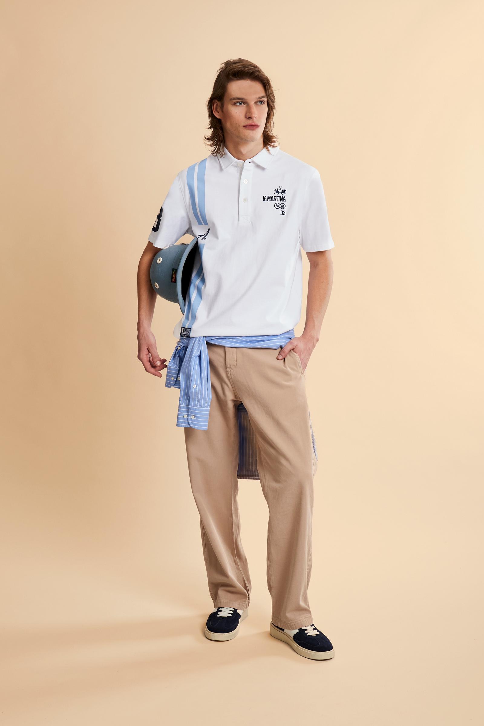 Men’s heavy cotton jersey polo with three-button placket and striped details. Celebratory maxi graphic and bold lettering. - Optic White