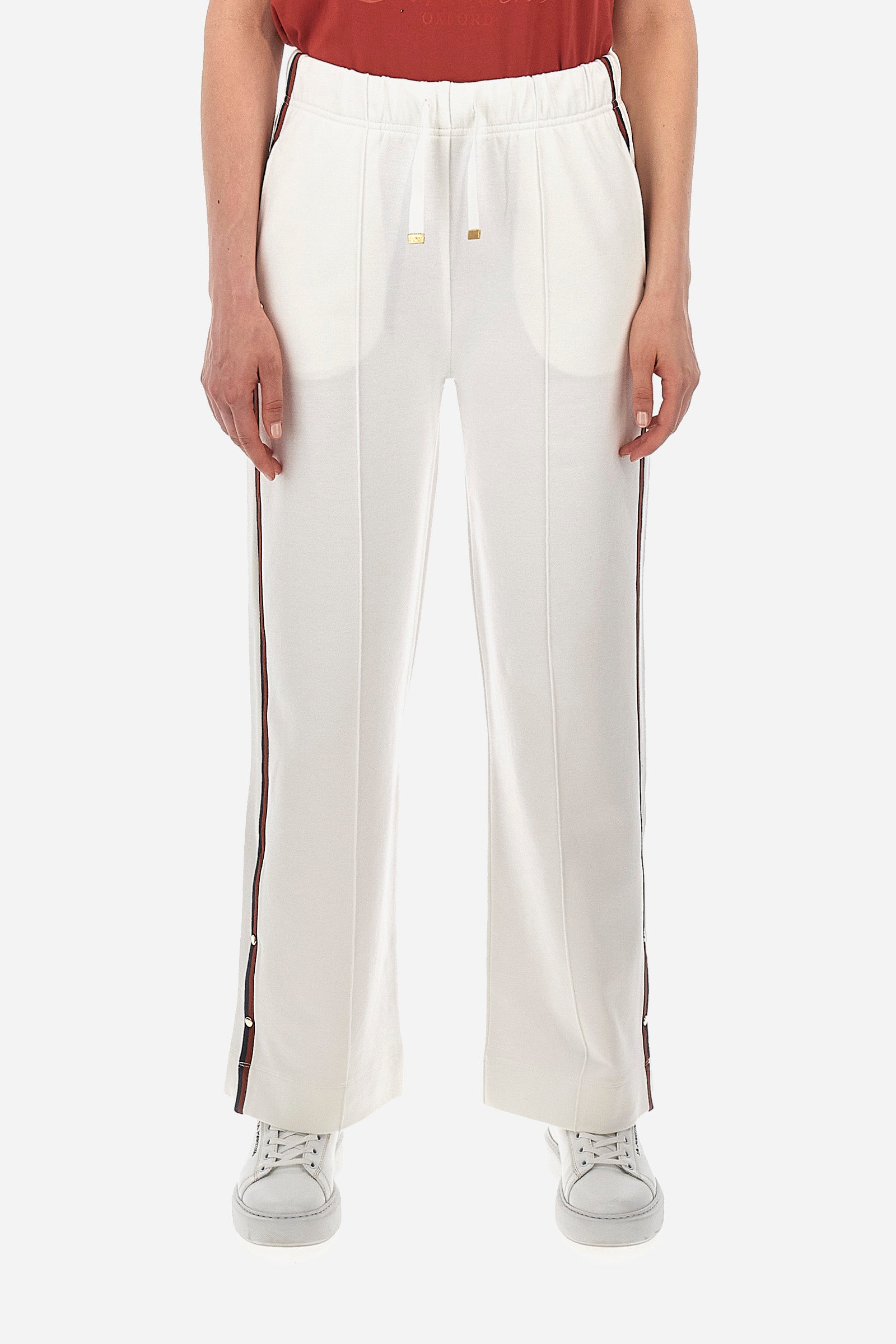 Women’s trousers in solid color, made of plush material. Wide leg with snap buttons on the end, which together with the contrasting tone edging along the entire leg recalls the Polo Academy line. Drawstring waist with drawstring closure and double front pocket. The metal label with logo is sewn on the side of a pocket. The fit is regular. The model wears a size 2. - Bone White